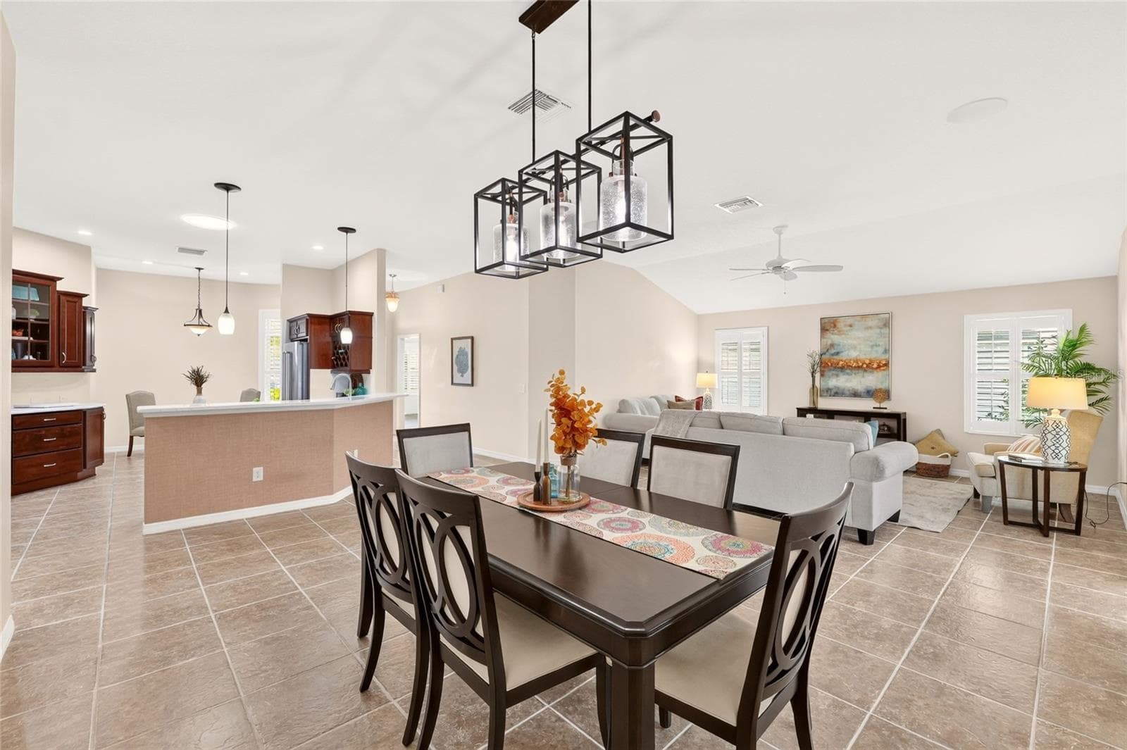 Inviting dining area with a stylish chandelier flows seamlessly into the spacious living room and kitchen—perfect for entertaining or everyday relaxation. - 2454 MORNING DOVE LN, THE VILLAGES