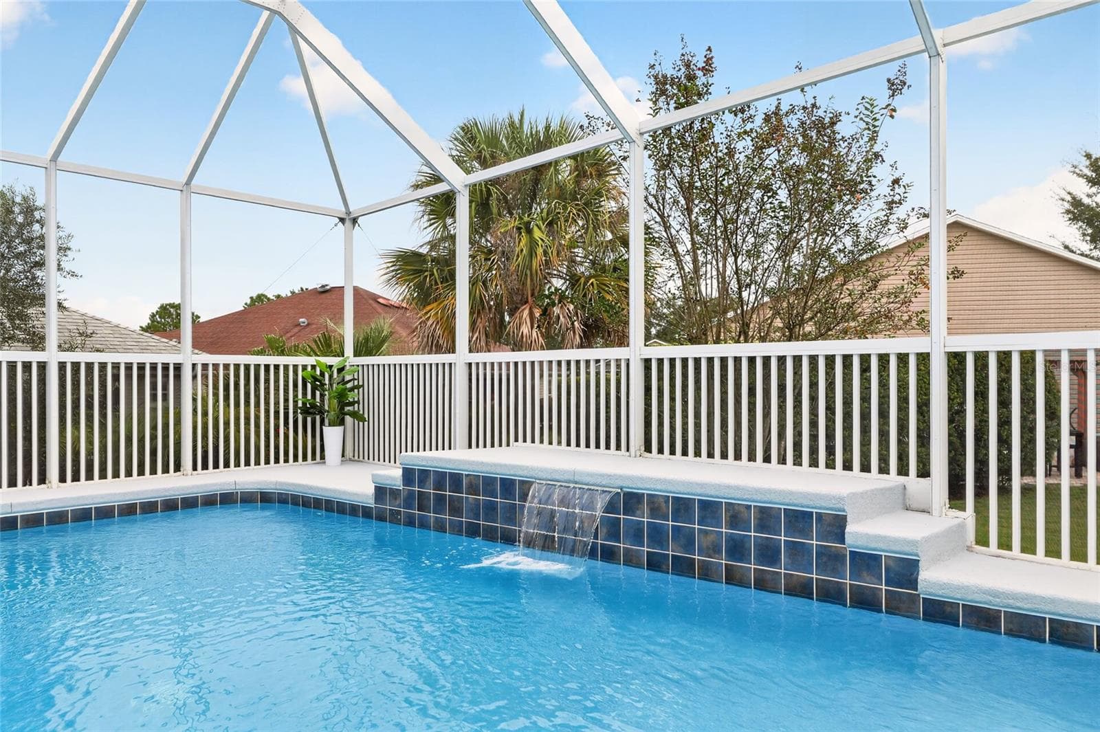Enjoy a refreshing dip in the sparkling pool while the soothing waterfall creates a relaxing retreat beneath the spacious screened birdcage. - 2454 MORNING DOVE LN, THE VILLAGES