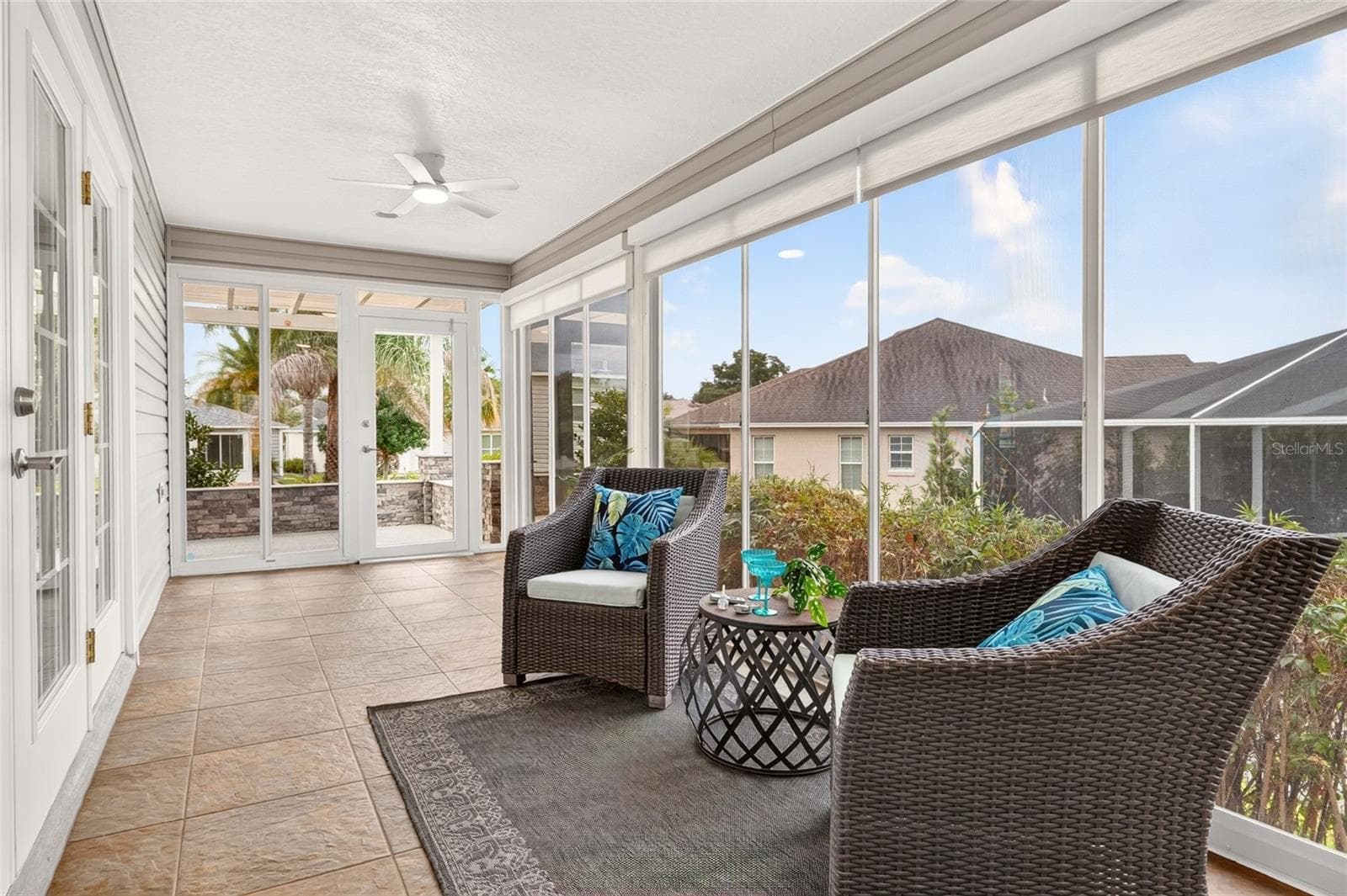 Bask in natural light in the ENCLOSED LANAI, featuring TILE FLOORING, expansive windows, and easy access to the PERGOLA PATIO—an inviting setting for morning coffee or relaxing with friends. - 2454 MORNING DOVE LN, THE VILLAGES