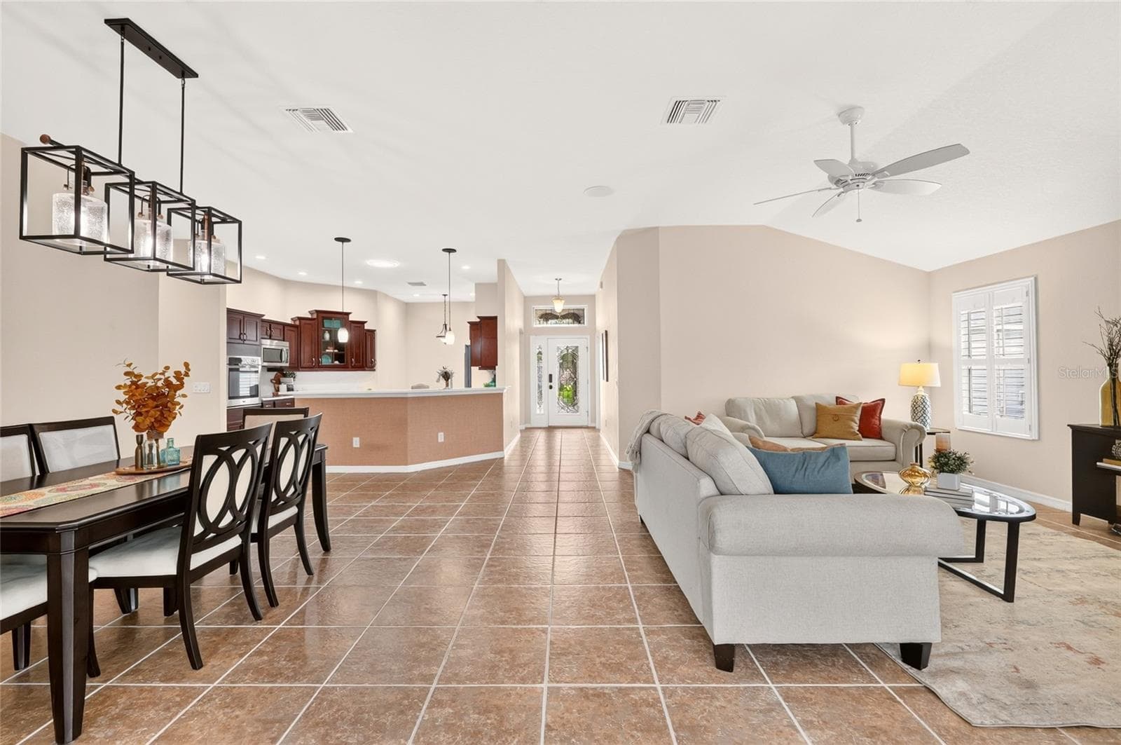 The bright, OPEN FLOOR PLAN brings the kitchen, dining, and living areas together beneath VOLUME CEILINGS, offering plenty of room to gather, entertain, and unwind. - 2454 MORNING DOVE LN, THE VILLAGES