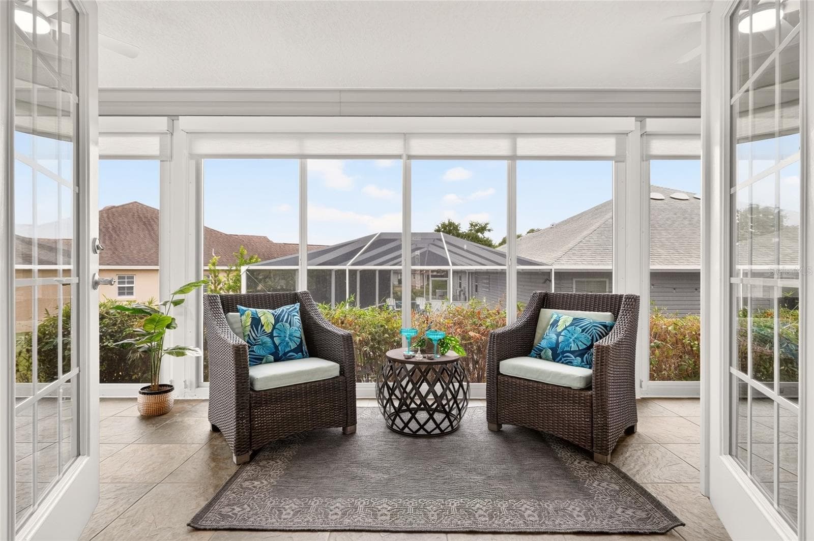 The sun-filled ENCLOSED LANAI features expansive windows, beautiful tile flooring, and access to the outdoor patio—an inviting setting for morning coffee, quiet reading, or conversation with friends. - 2454 MORNING DOVE LN, THE VILLAGES