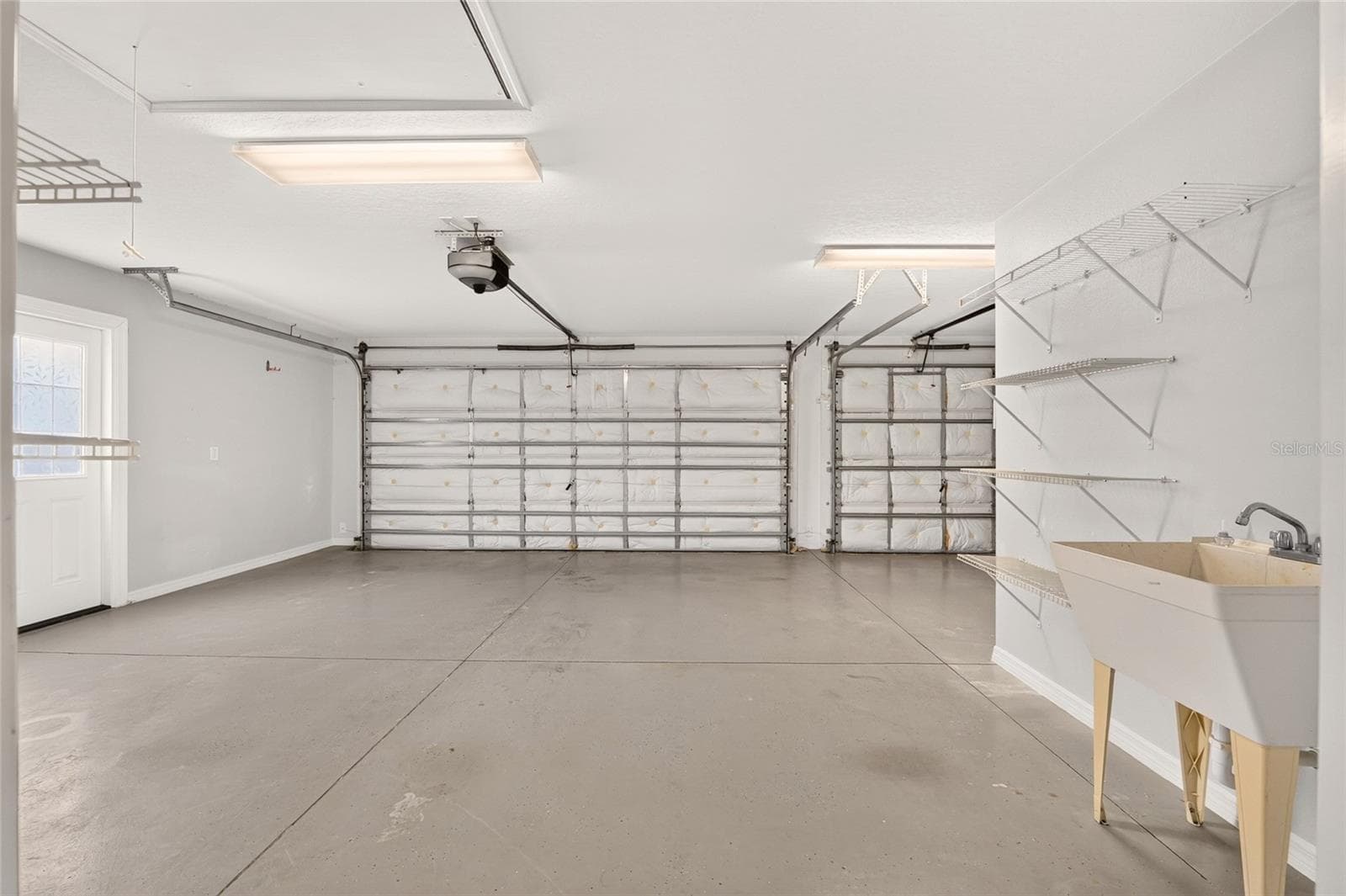 A TWO-CAR PLUS GOLF CART GARAGE offers ample parking, with a programmable, app-controlled garage door opener and camera for convenient remote access and monitoring from wherever you are. - 2454 MORNING DOVE LN, THE VILLAGES