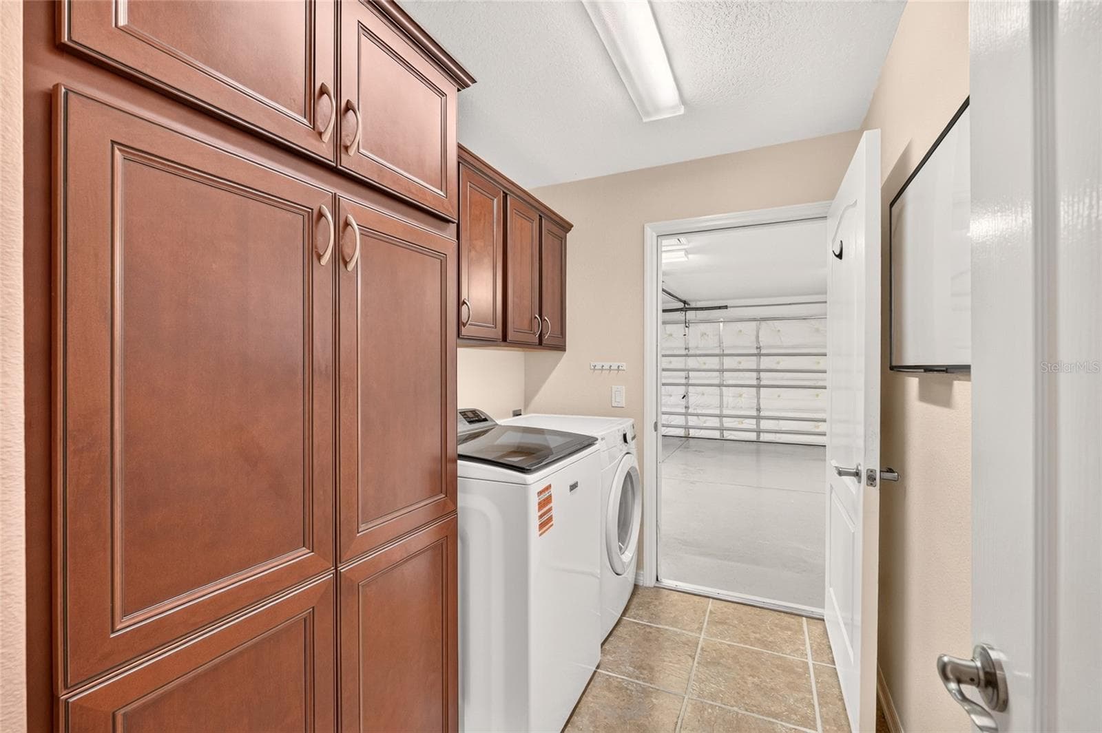 A TWO-CAR PLUS GOLF CART GARAGE offers ample parking, with a programmable, app-controlled garage door opener and camera for convenient remote access and monitoring from wherever you are. - 2454 MORNING DOVE LN, THE VILLAGES