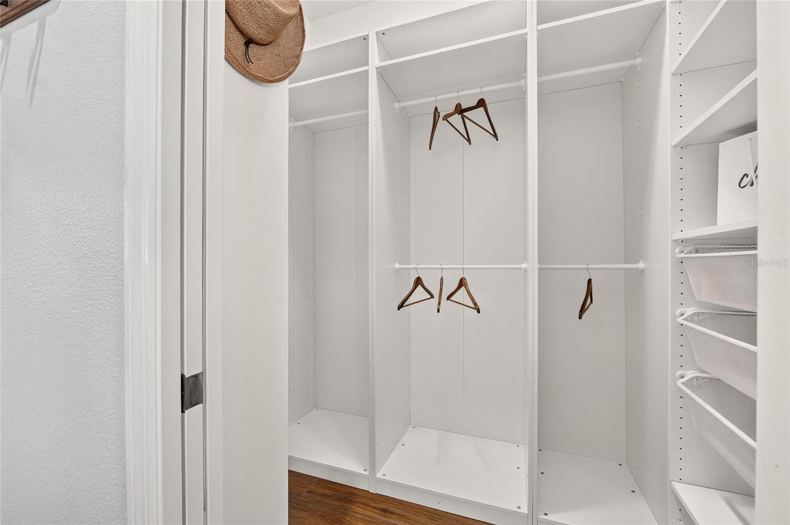 A beautifully organized CUSTOM WALK-IN CLOSET features adjustable shelving, multiple hanging rods, and pull-out baskets to keep clothing and accessories neatly within reach. - 2454 MORNING DOVE LN, THE VILLAGES