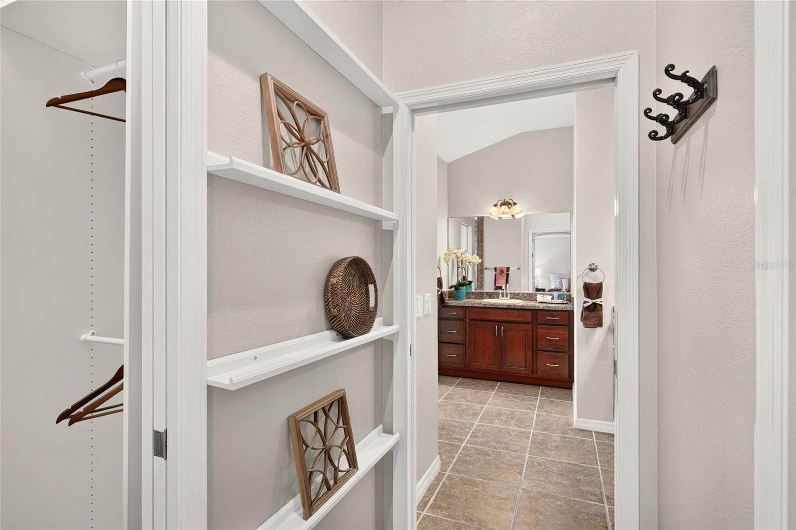 CUSTOM CLOSET shelving and multiple hanging rods keep wardrobe essentials organized, with convenient access to the PRIMARY BATH. - 2454 MORNING DOVE LN, THE VILLAGES