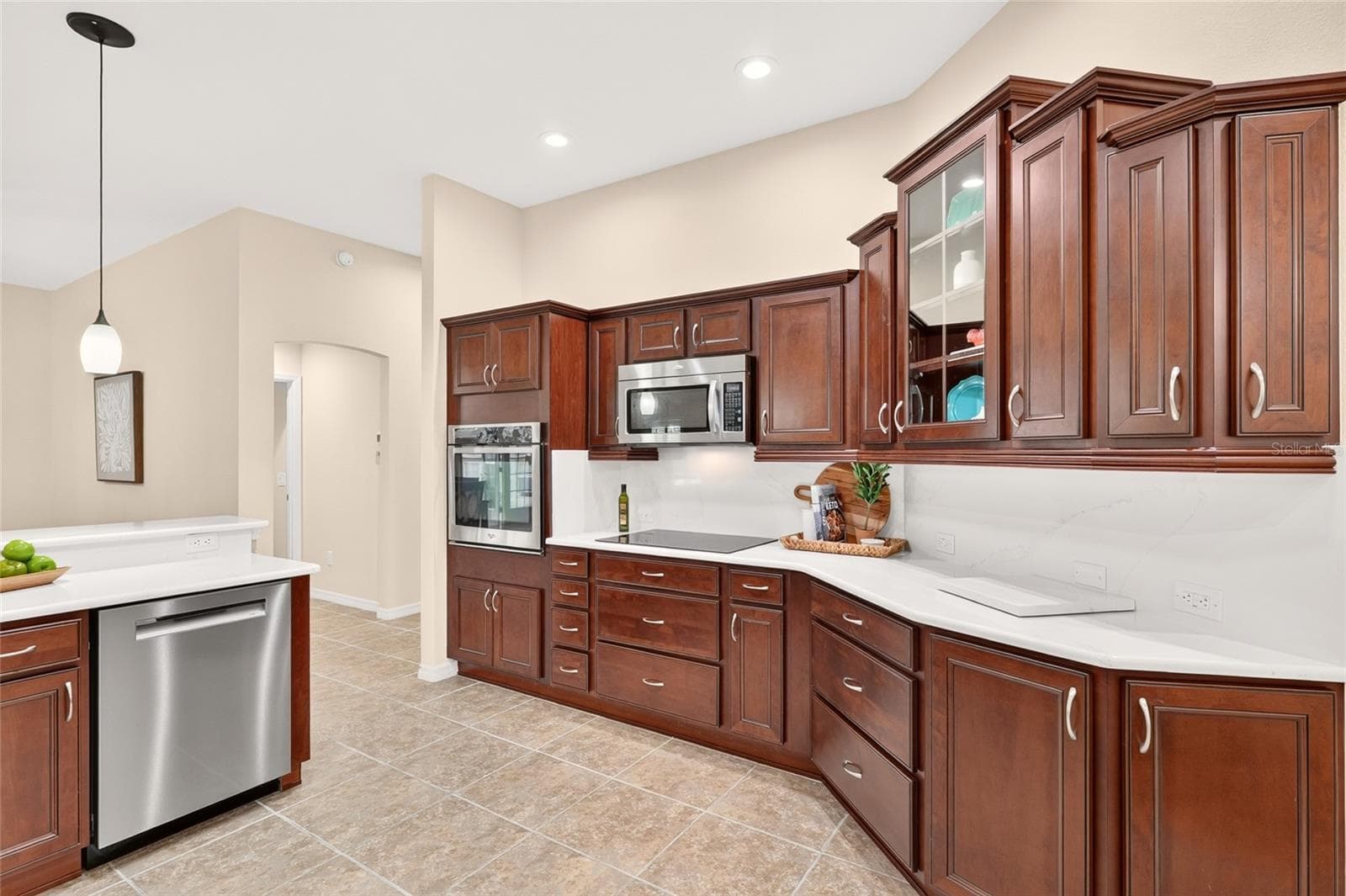 Beautiful CROWNED CABINETRY, QUARTZ COUNTERTOPS, and STAINLESS STEEL APPLIANCES create an inviting kitchen with a spacious breakfast bar for casual dining and conversation. - 2454 MORNING DOVE LN, THE VILLAGES