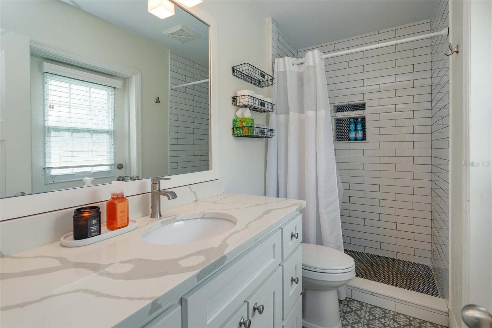 Renovated primary shower with shaker vanity, stone counter, new lighting and fixtures - 2322 WOODCREST DR, WINTER PARK