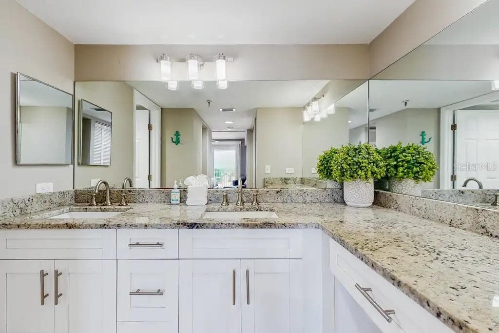 EN-SUITE BATHROOM WITH SEPARATE DRESSING AREA, DOUBLE SINKS, AND LARGE WALK-IN CLOSET WITH BUILT- IN WARDROBE ORGANIZERS COMPLETES THE SPACIOUS PRIMARY SUITE. - 18400 GULF BLVD #1208, INDIAN SHORES