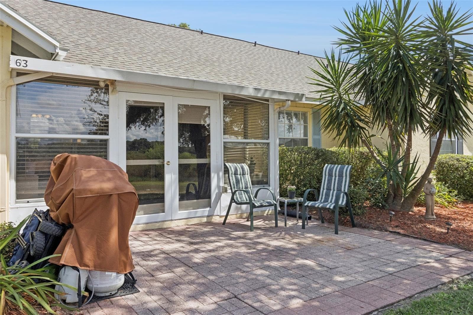 Fabulous Florida foliage flanks the oversized paver patio. - 1066 VILLA LN #63, APOPKA