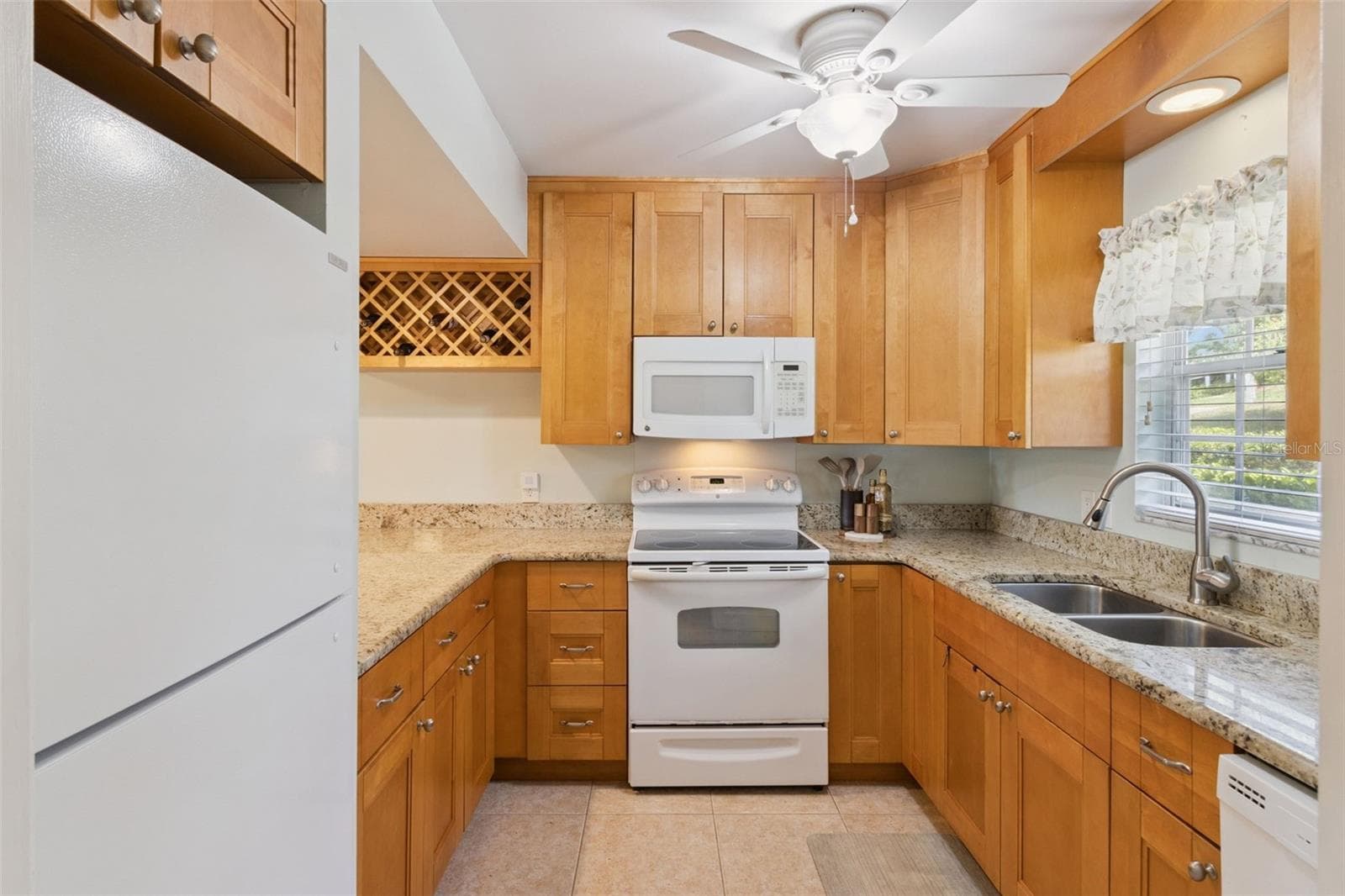 Richly endowed with gorgeous granite counters and a wealth of wood cabinets make this kitchen fun and functional. - 1066 VILLA LN #63, APOPKA