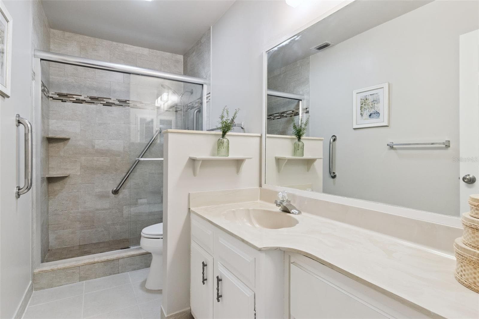 Spacious en suite bath with wide marble vanity, multiple drawers and ceramic tile flooring. - 1066 VILLA LN #63, APOPKA