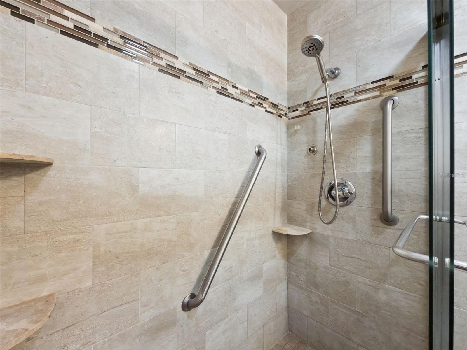 Stunning en suite, glass-enclosed shower with floor-to-ceiling and designer linear tiles plus built-in shelves. - 1066 VILLA LN #63, APOPKA