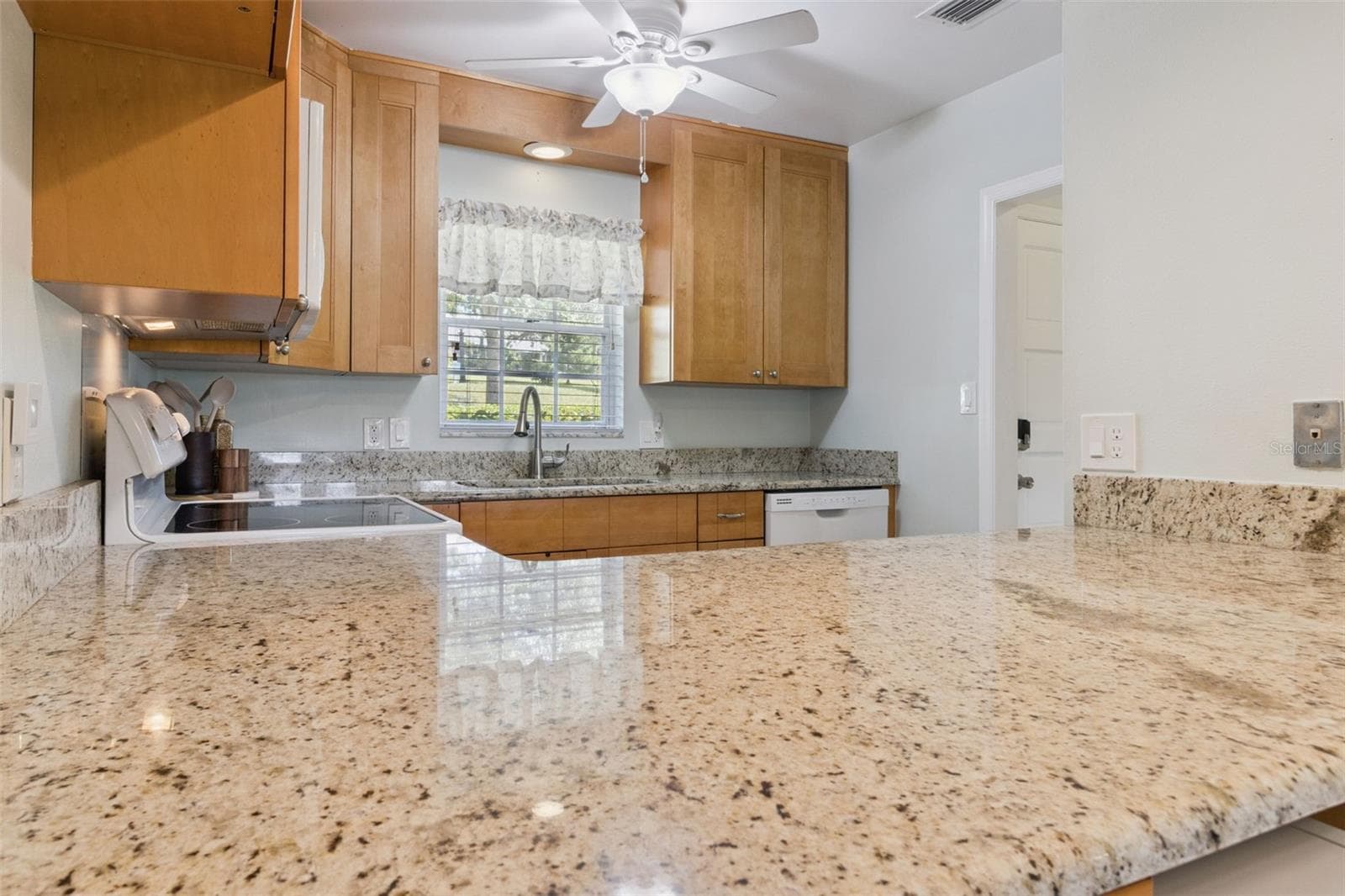 Abundant granite gleams throughout the kitchen. - 1066 VILLA LN #63, APOPKA