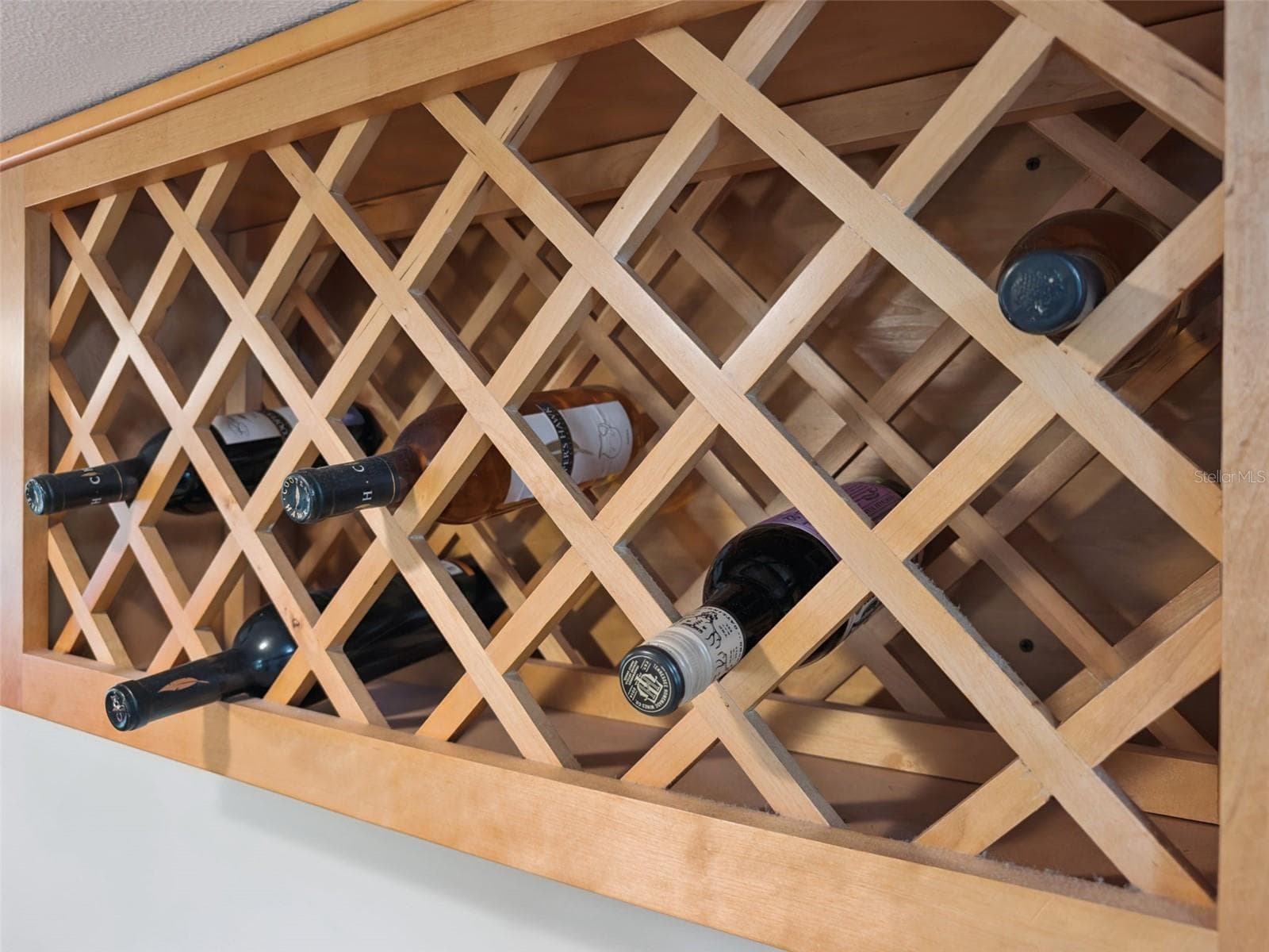 Built-in wine rack matches the rich tones of the wood cabinets. - 1066 VILLA LN #63, APOPKA