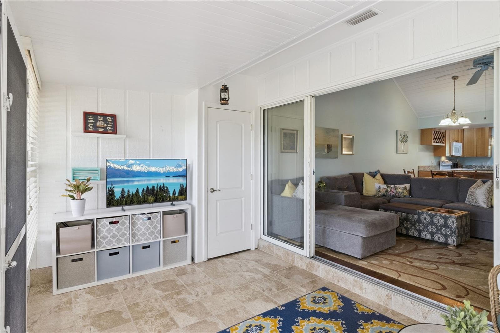 Sunroom has stunning custom tile flooring and a handy storage closet. - 1066 VILLA LN #63, APOPKA