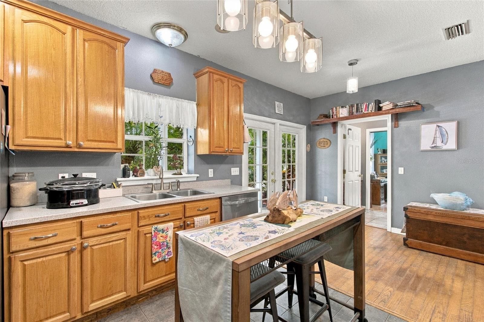 Kitchen has stainless steel appliances and lots of cabinetry! The French doors open out to the side porch. The doorway in the rear leads into a full bath and the 4th bedroom. - 3850 GRANADA DR, INDIAN LAKE ESTATES