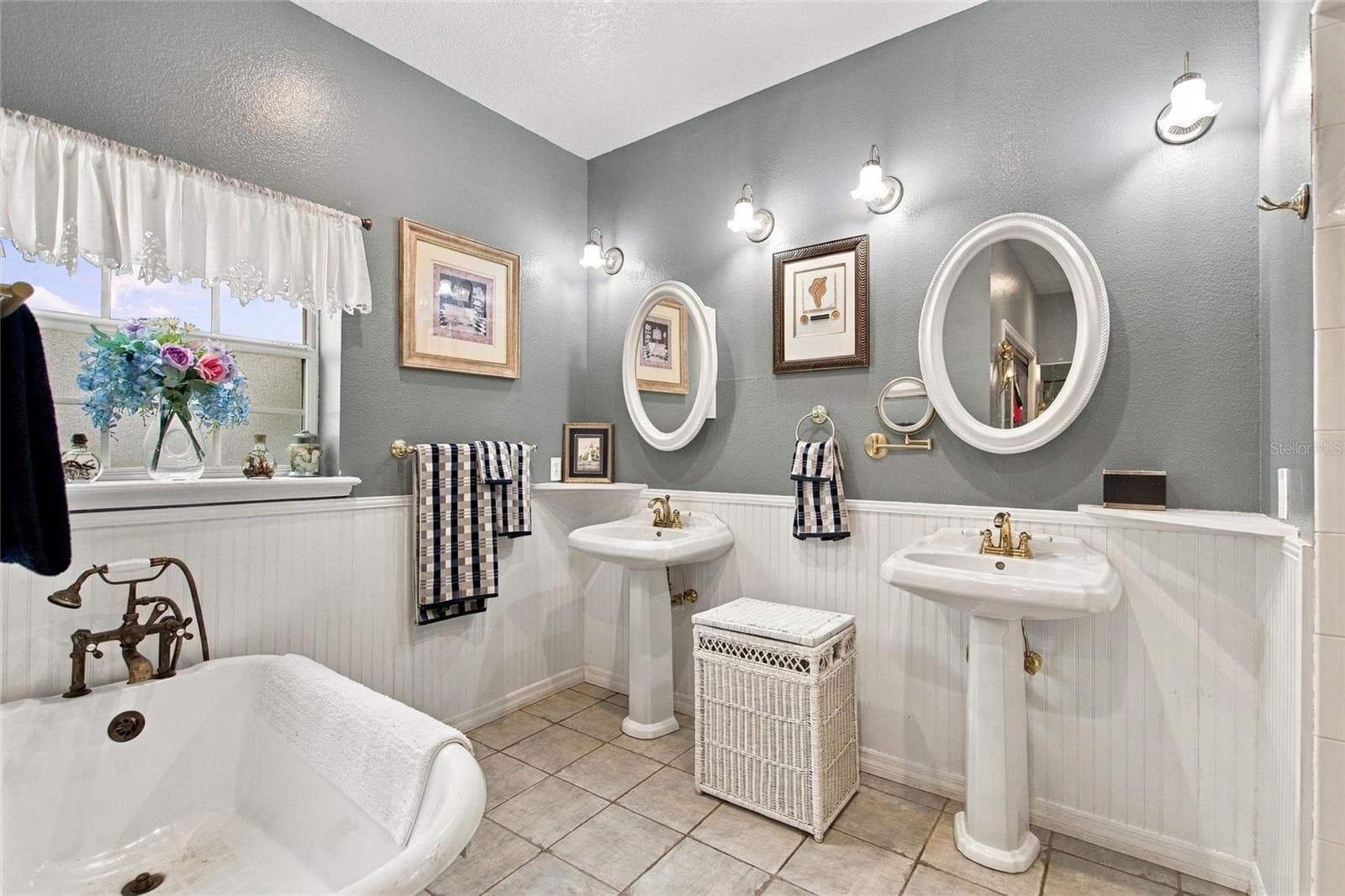 The primary bedroom has a clawfoot bath tub, two pedastal sinks, shower and water closet. - 3850 GRANADA DR, INDIAN LAKE ESTATES