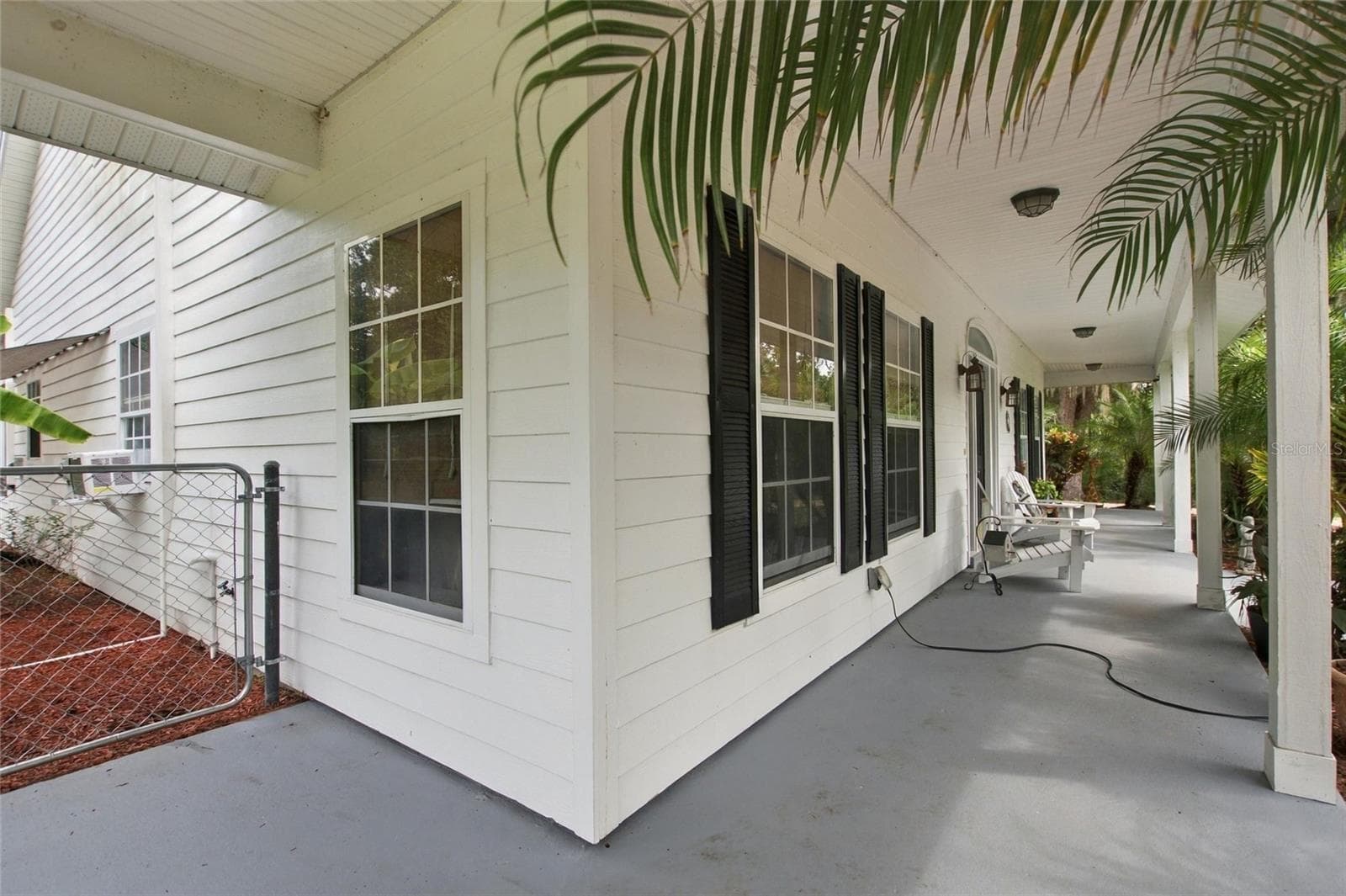 Front porch that wraps around to the garage side. - 3850 GRANADA DR, INDIAN LAKE ESTATES