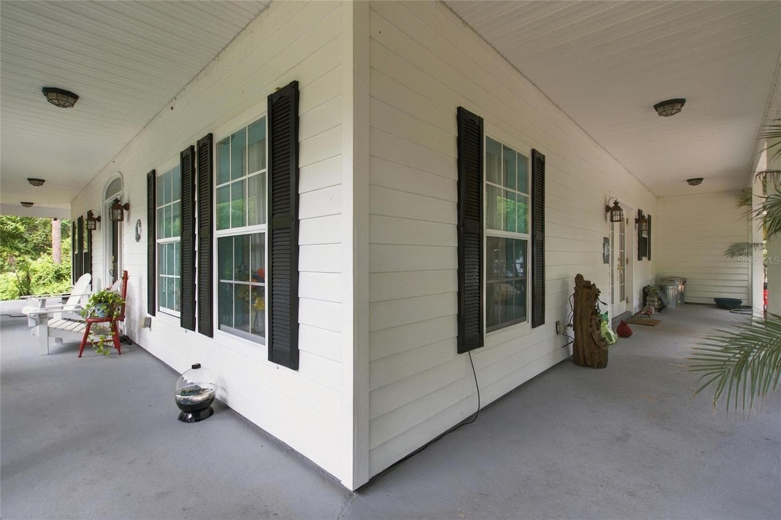 Front porch showing area that wraps around to the kitchen ending in the garage wall. - 3850 GRANADA DR, INDIAN LAKE ESTATES