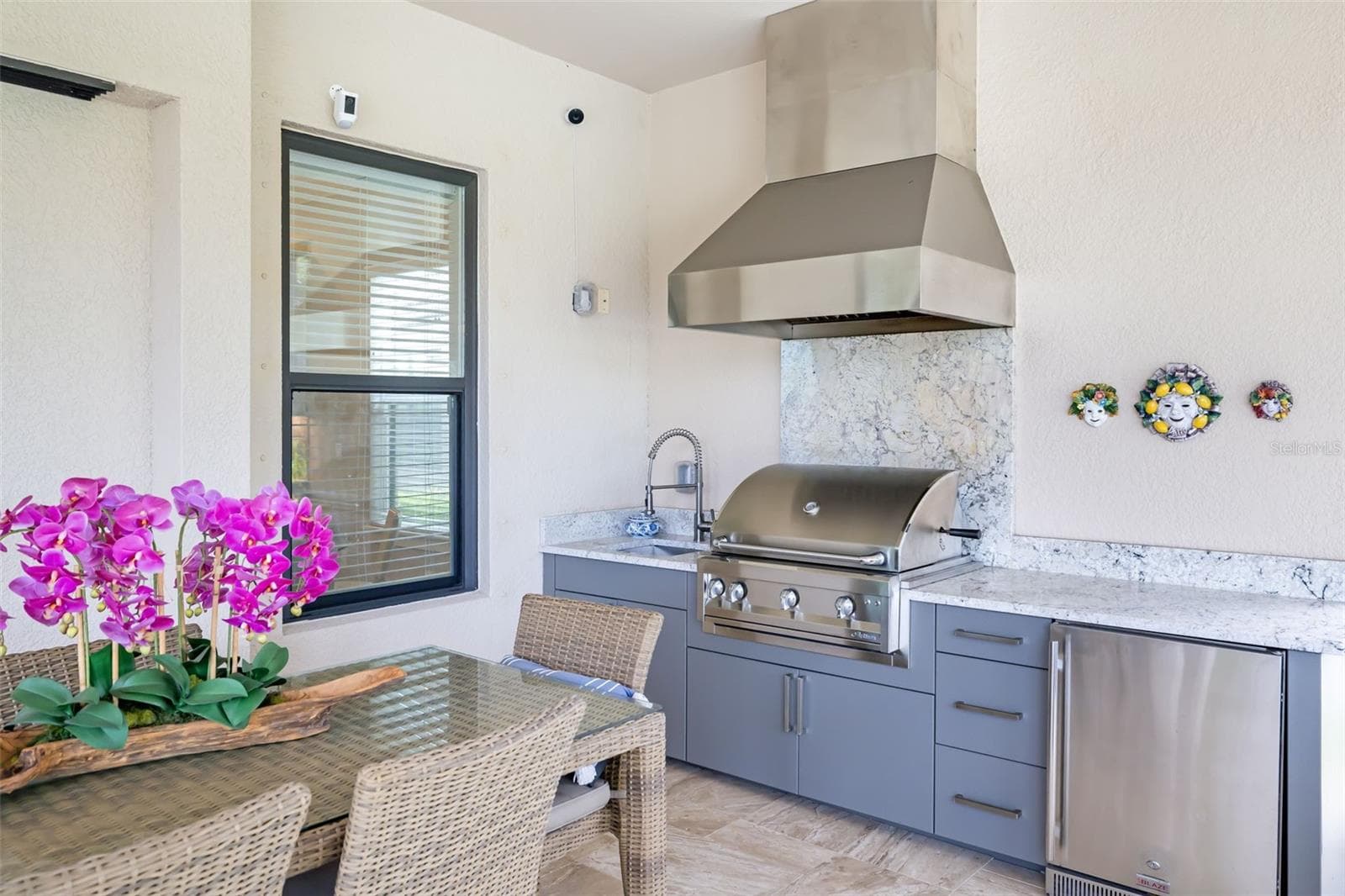 The summer kitchen is well equipped with a vented gas grill, sink and small refrigerator - 12807 SORRENTO WAY, BRADENTON