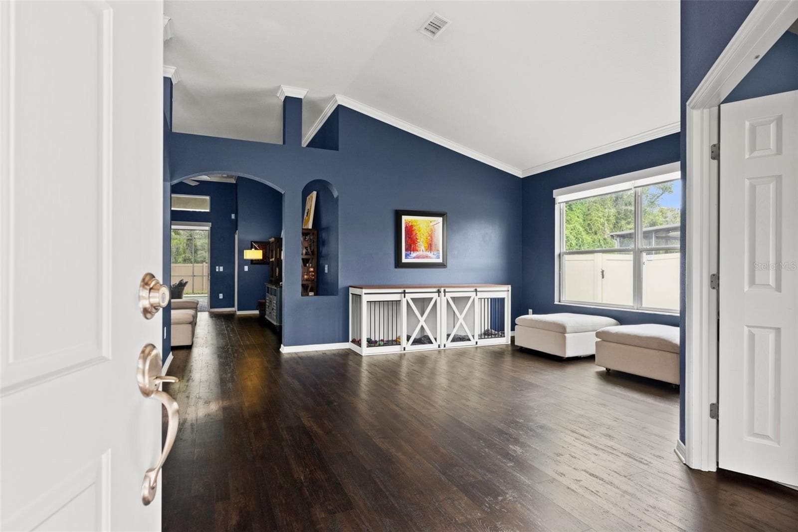 Step inside to a bright, open interior where high ceilings and rich flooring immediately create a sense of space. - 1419 BLUE MARLIN BLVD, HOLIDAY
