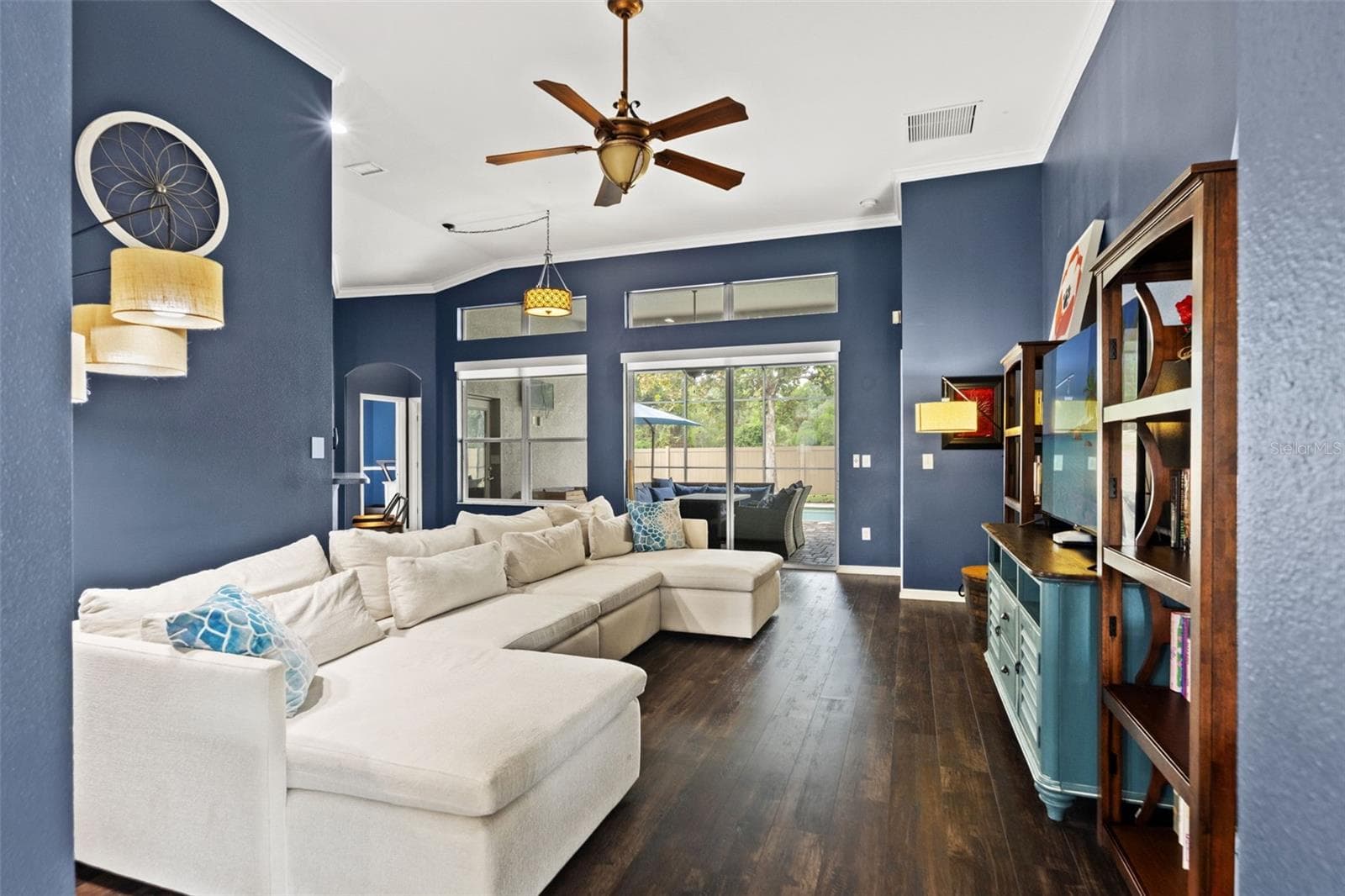 Natural light pours into the family room, with views toward the screened pool and outdoor living area. - 1419 BLUE MARLIN BLVD, HOLIDAY