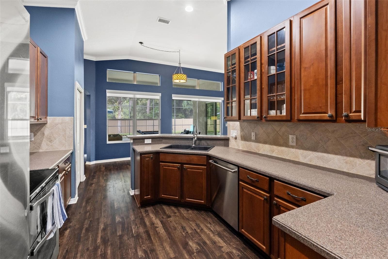 A large window over the sink brings natural light into the kitchen and provides a view toward the outdoor living area. - 1419 BLUE MARLIN BLVD, HOLIDAY