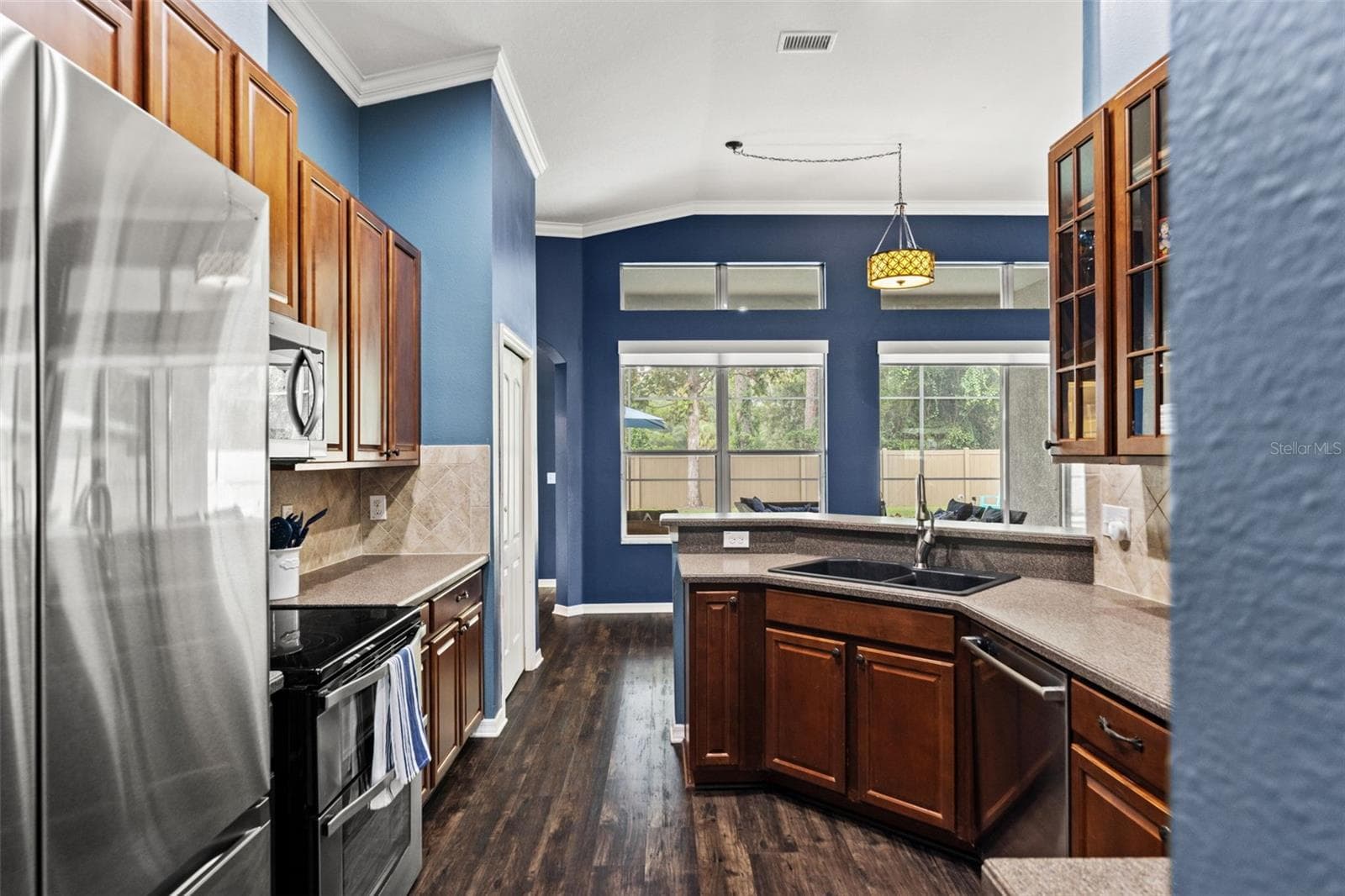 Generous cabinetry and counter space line both sides of the kitchen, creating a functional workspace with excellent storage. - 1419 BLUE MARLIN BLVD, HOLIDAY