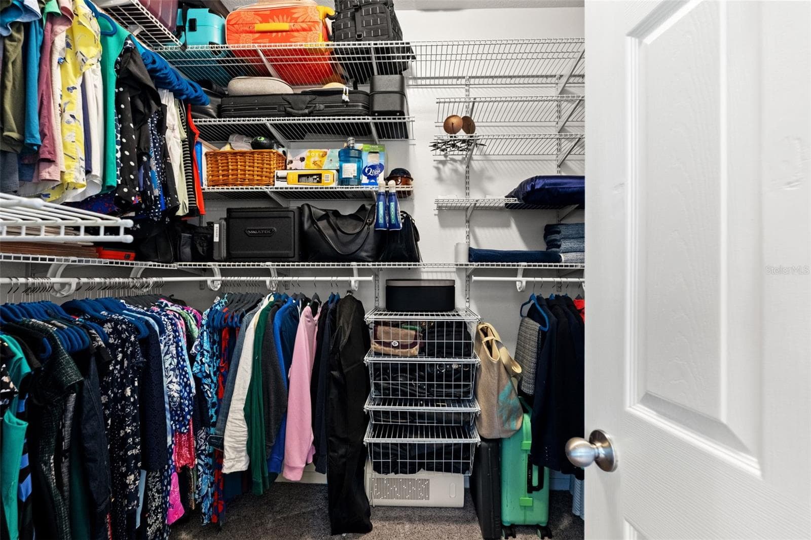 A large walk-in closet with built-in organization provides plenty of room to keep clothing, shoes, and accessories neatly arranged. - 1419 BLUE MARLIN BLVD, HOLIDAY