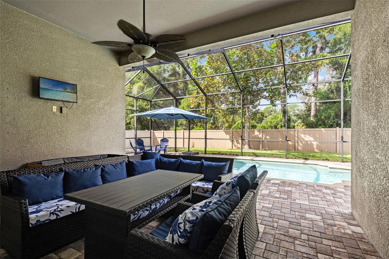 Welcome to the Florida room you’ll actually use—a covered outdoor living area overlooking the screened saltwater pool. - 1419 BLUE MARLIN BLVD, HOLIDAY