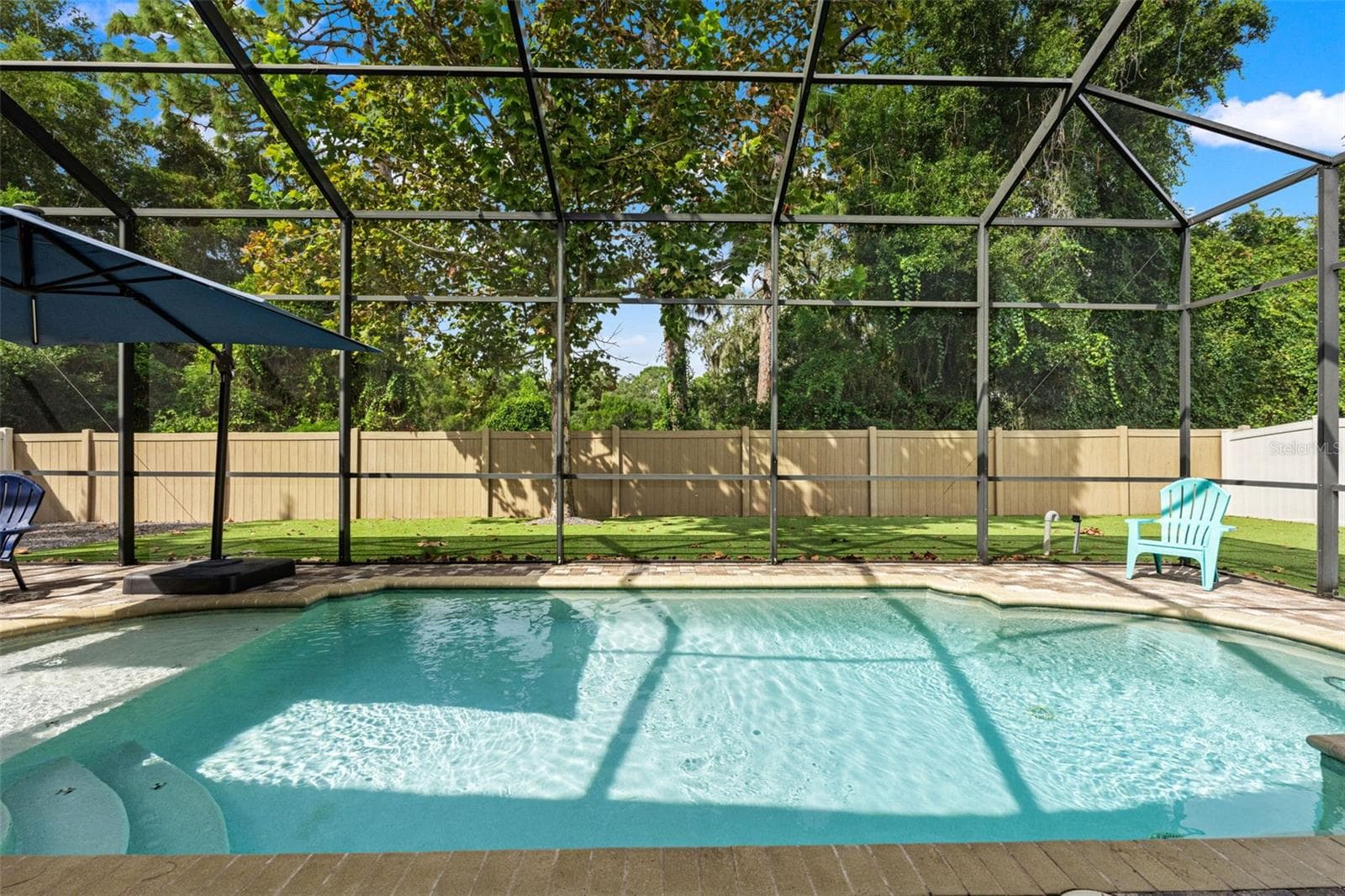 The screened saltwater pool is the centerpiece of this private backyard retreat, ready for sunny afternoons and weekend swims. - 1419 BLUE MARLIN BLVD, HOLIDAY