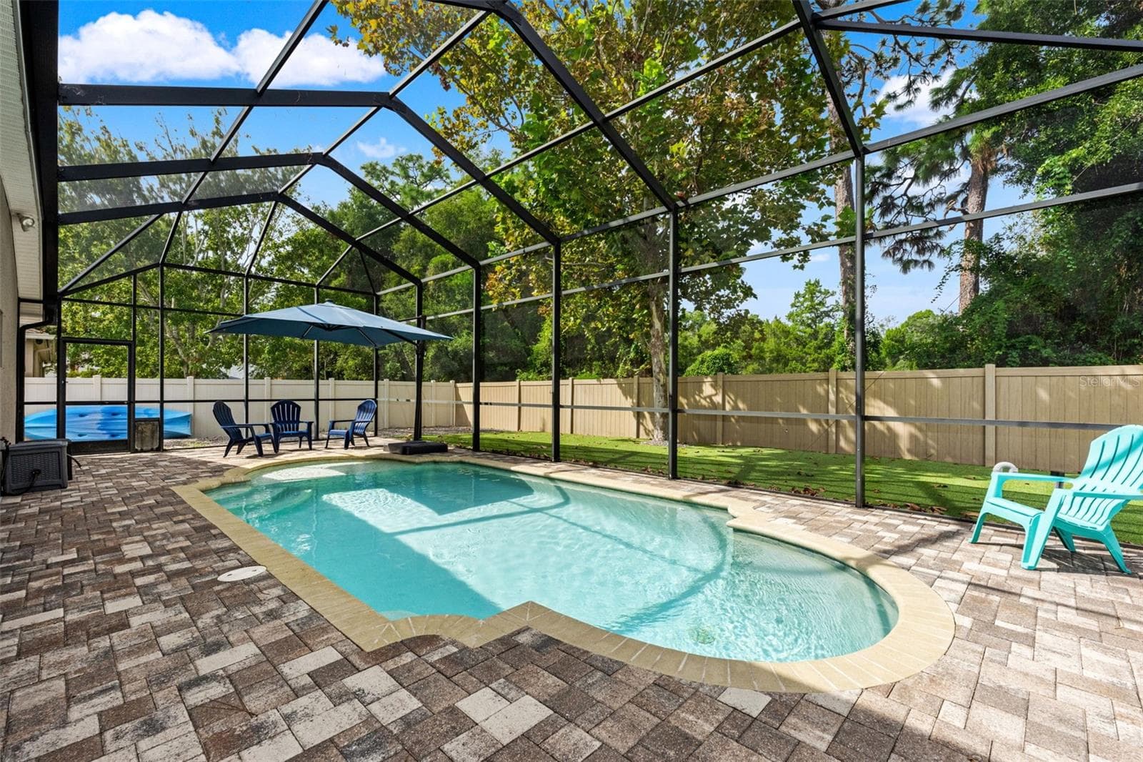 A spacious paver pool deck provides plenty of room for loungers, conversation areas, and entertaining around the water. - 1419 BLUE MARLIN BLVD, HOLIDAY