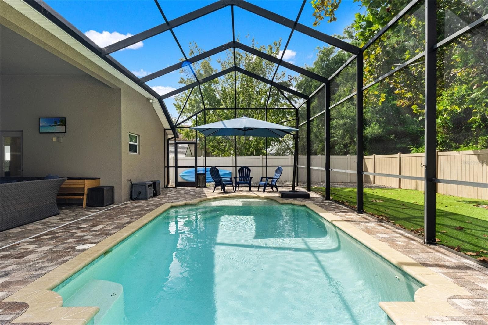 The full screen enclosure lets you enjoy the saltwater pool while still feeling connected to the surrounding outdoor space. - 1419 BLUE MARLIN BLVD, HOLIDAY