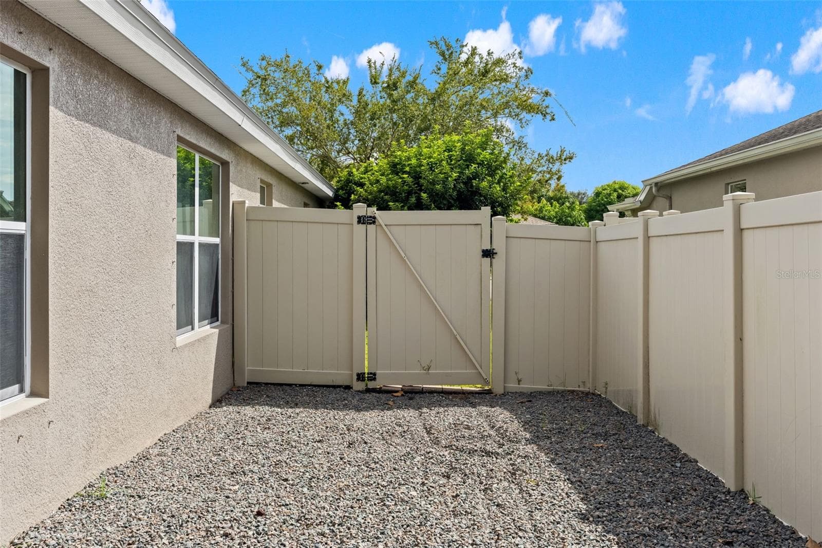 A gated side area provides additional usable outdoor space separate from the main pool and backyard areas. - 1419 BLUE MARLIN BLVD, HOLIDAY