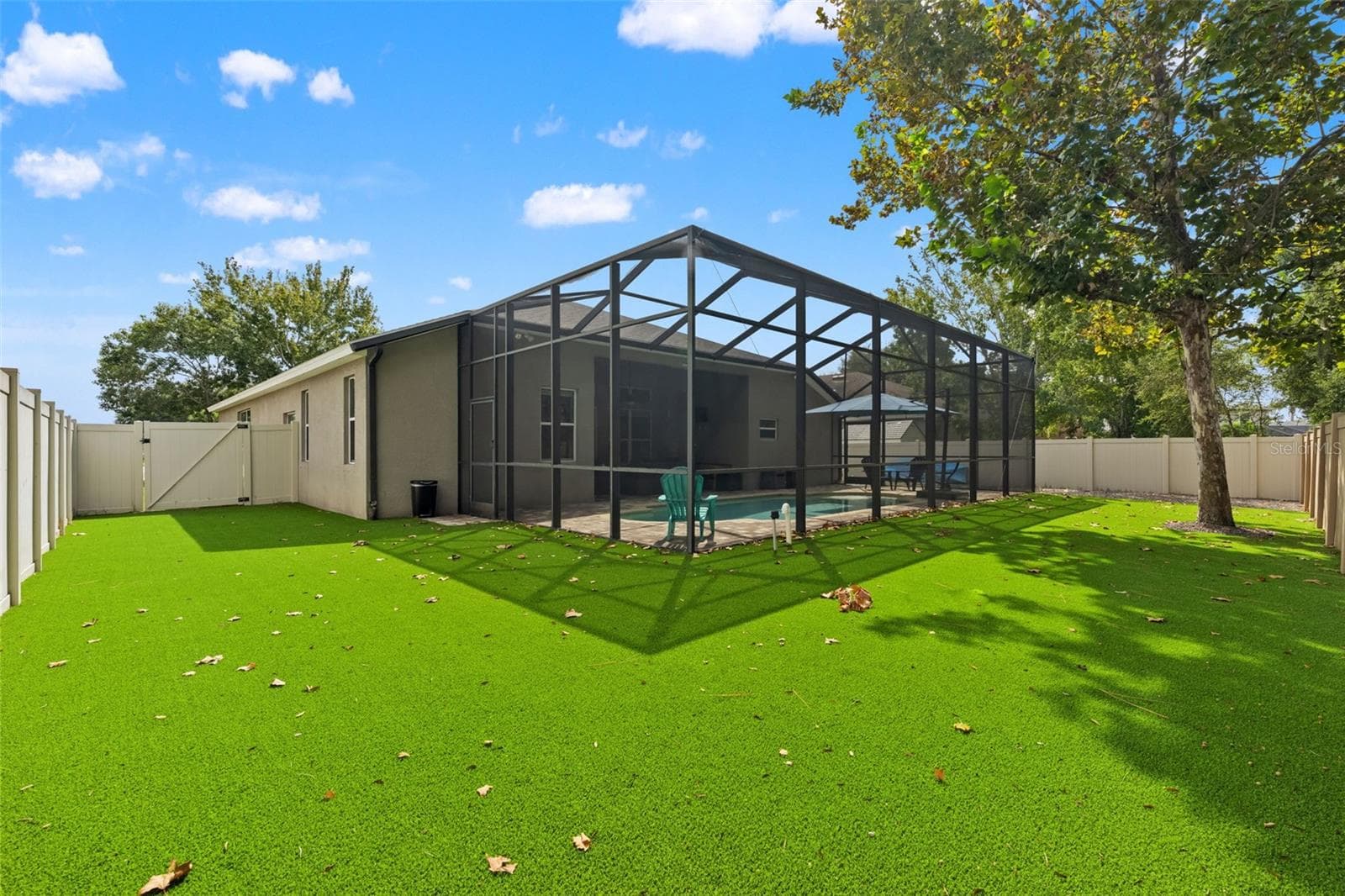 The fenced backyard extends beyond the pool enclosure, giving you additional outdoor space without rear neighbors directly behind you. - 1419 BLUE MARLIN BLVD, HOLIDAY