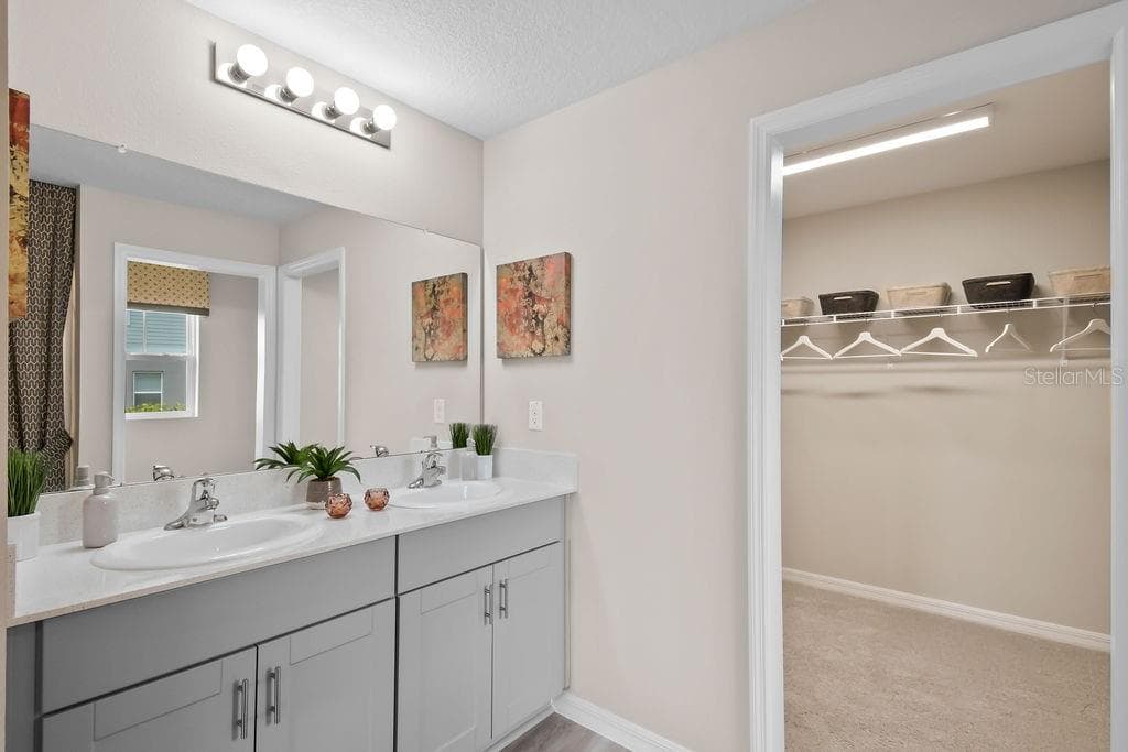 Primary bathroom with double sinks and large walk-in closet - 5945 SLATE ROCK DR, LAKELAND