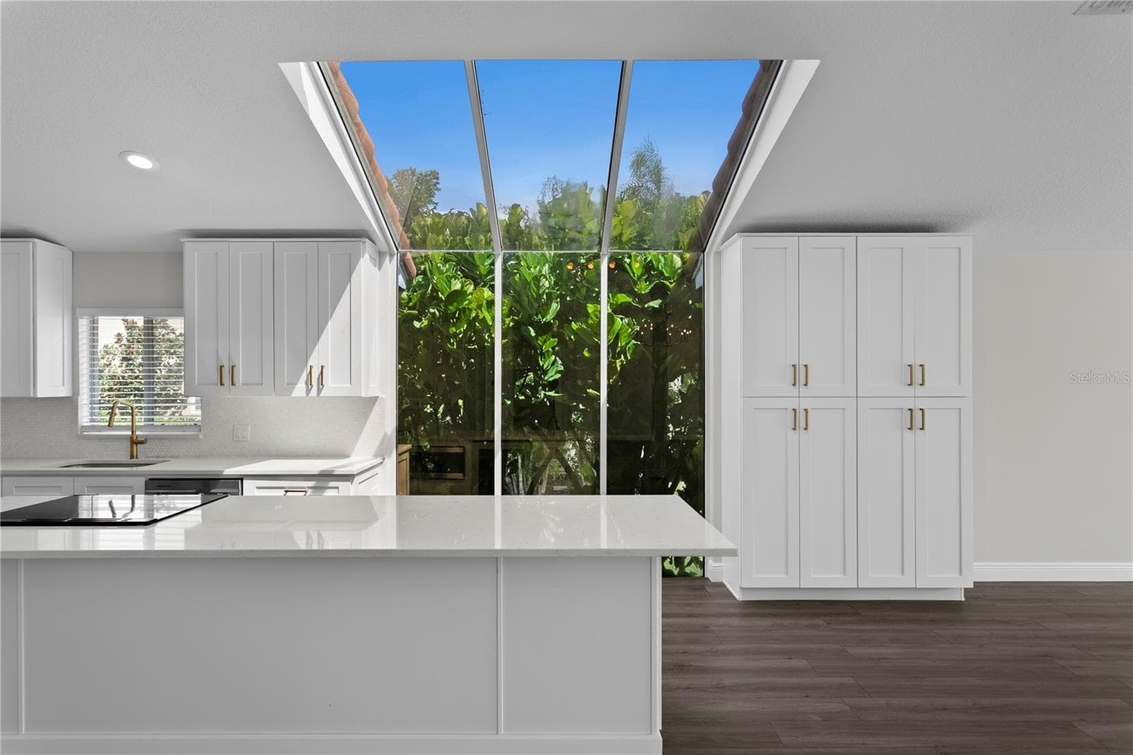 Floor-to-ceiling windows fill the gorgeous kitchen with natural light, complemented by abundant cabinet storage. - 6402 RUBIA CIR, APOLLO BEACH