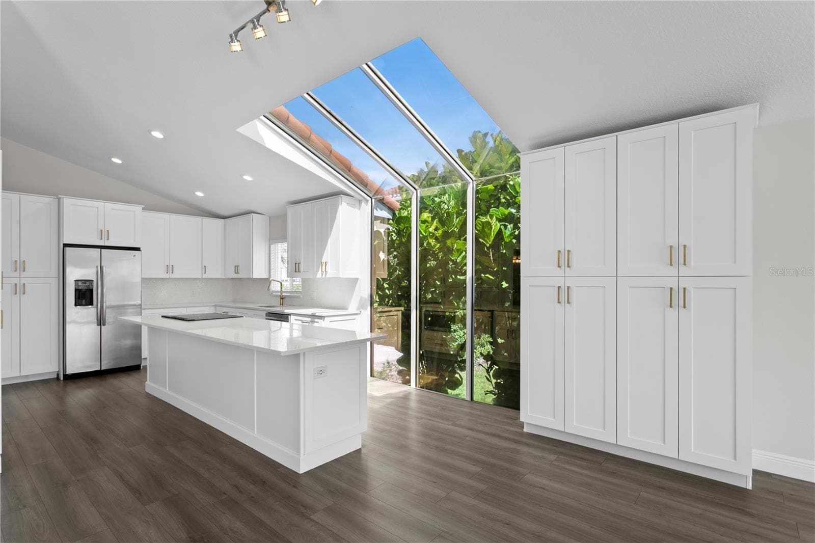 This gorgeous kitchen features stainless steel appliances (new in 2020) and stunning quartz countertops. - 6402 RUBIA CIR, APOLLO BEACH