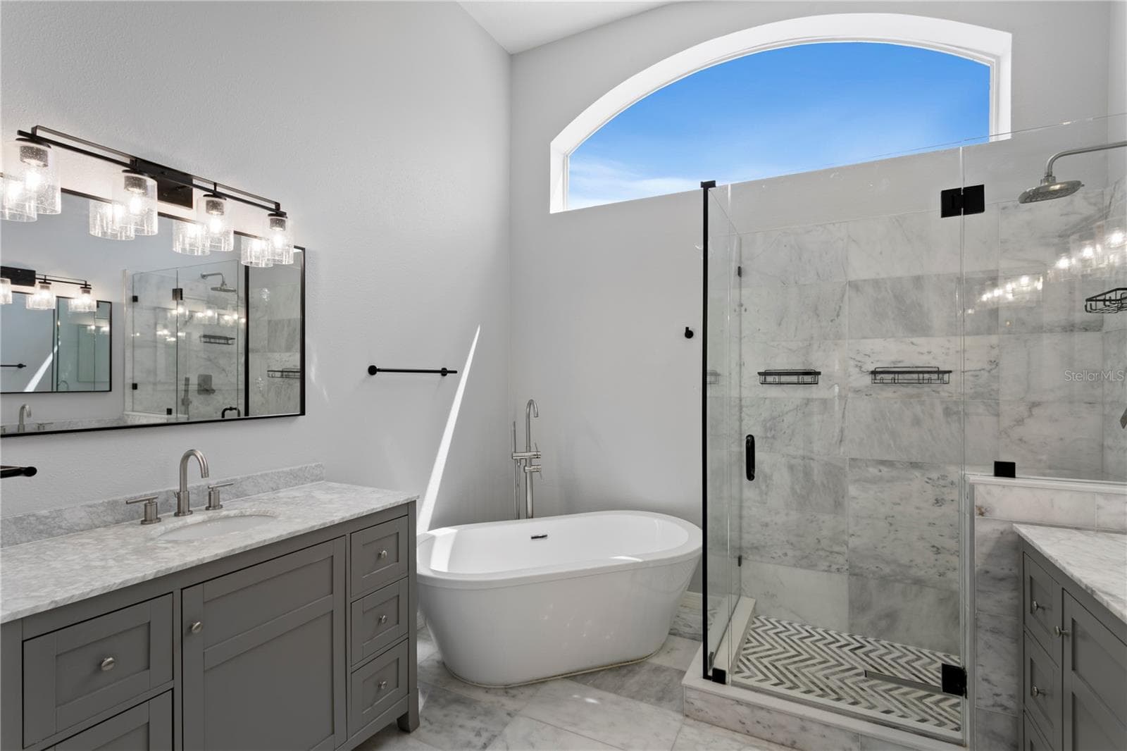 The elegant primary bath features dual vanities, a luxurious soaking tub and oversized walk-in shower. - 6402 RUBIA CIR, APOLLO BEACH
