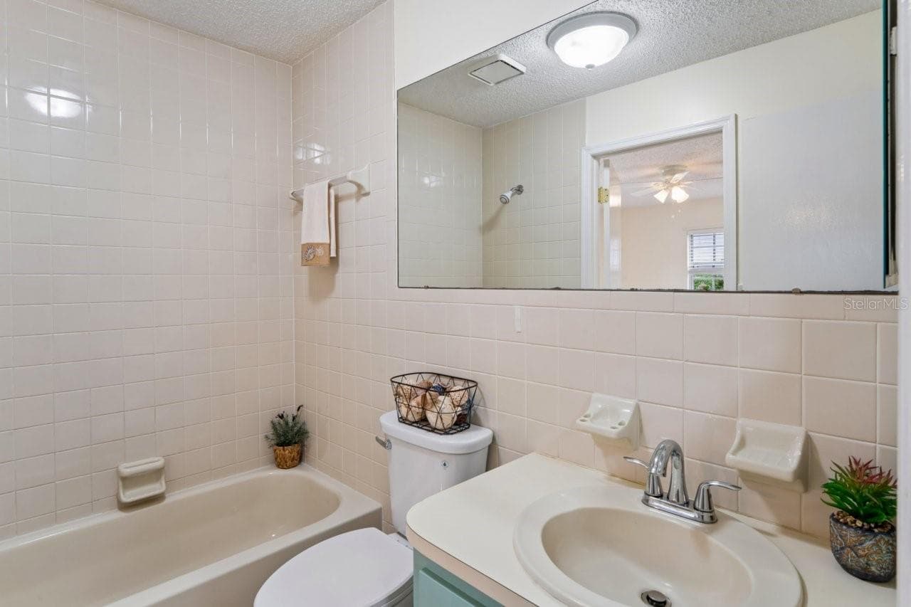 The bathroom features a tub with a shower and a single vanity, with access from both the bedroom and the living room. - 6709 DEVONSHIRE LN #10A, NEW PORT RICHEY