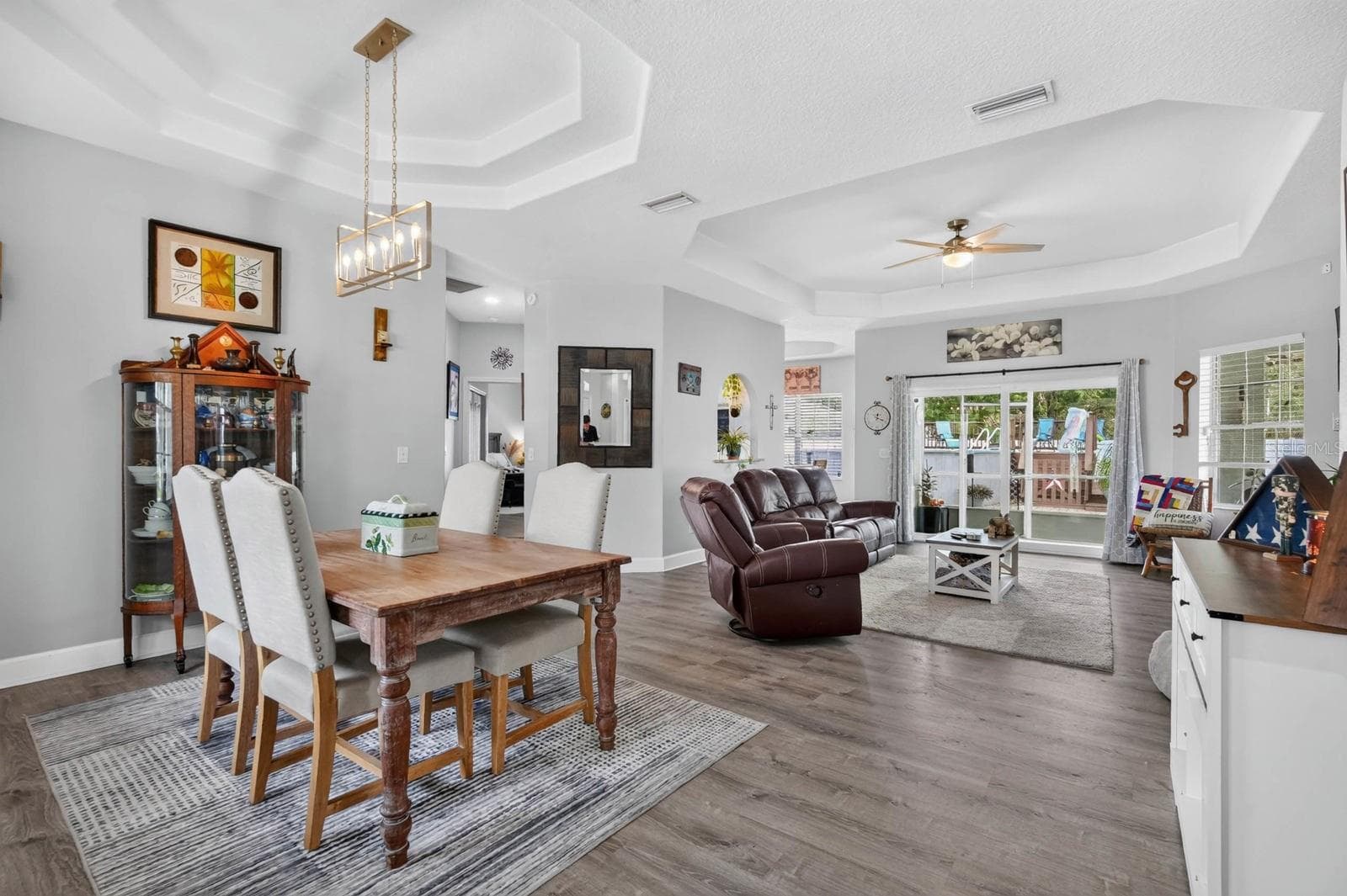 beautiful open dining and living area overlooks backyard with a set of sliders out that go outside to covered and screened lanai - 72 KARAS TRL, PALM COAST