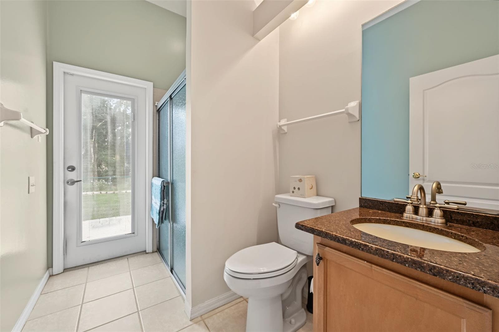 Third bathroom at rear of home next to fourth bedroom. Door leading to back yard and pool area. - 1028 HAGEN DR, NEW PORT RICHEY