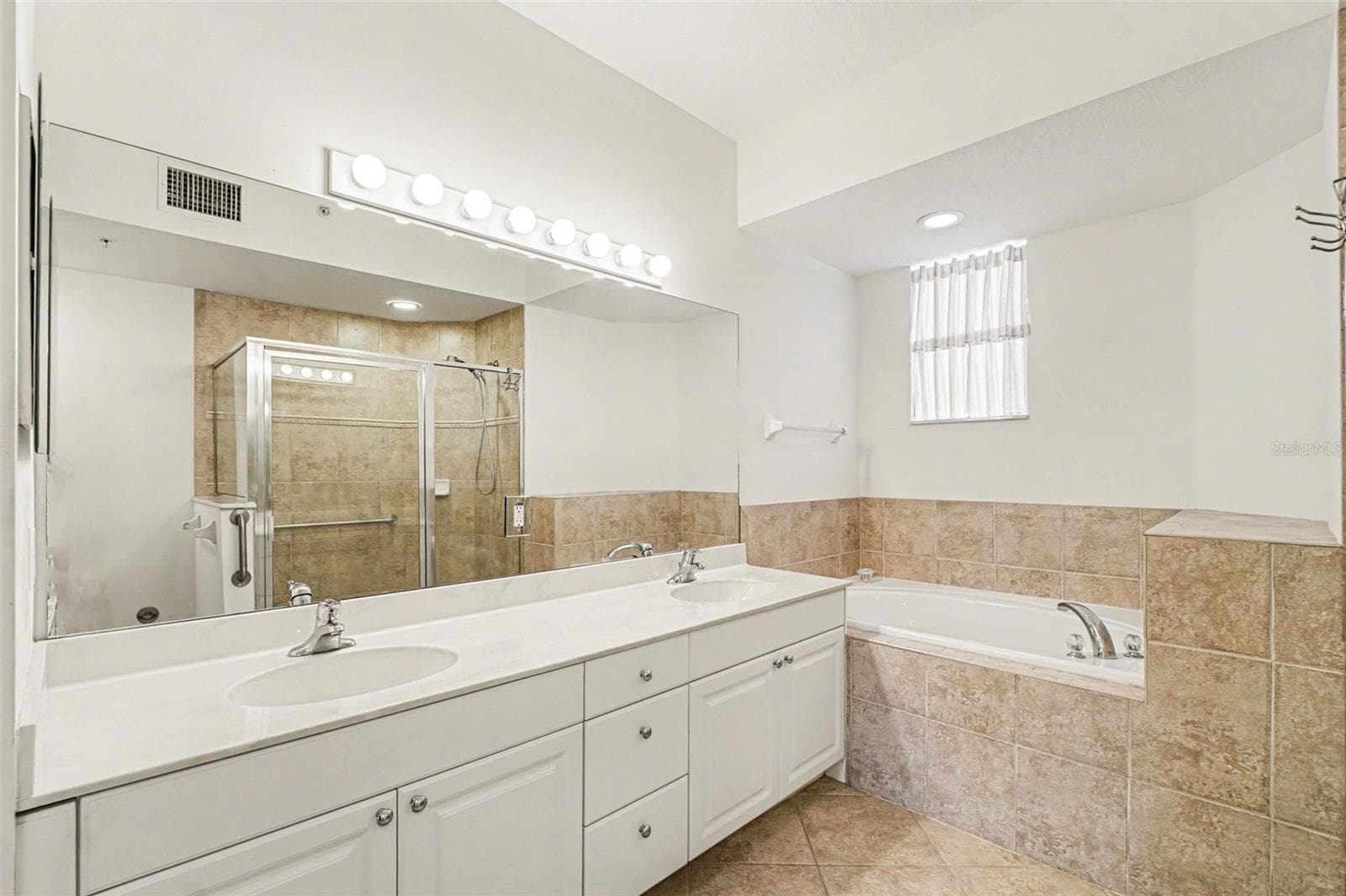 Primary Bathroom with dual sink vanity, soaking tub and walk in shower. - 4683 CLUB DR #101, PORT CHARLOTTE