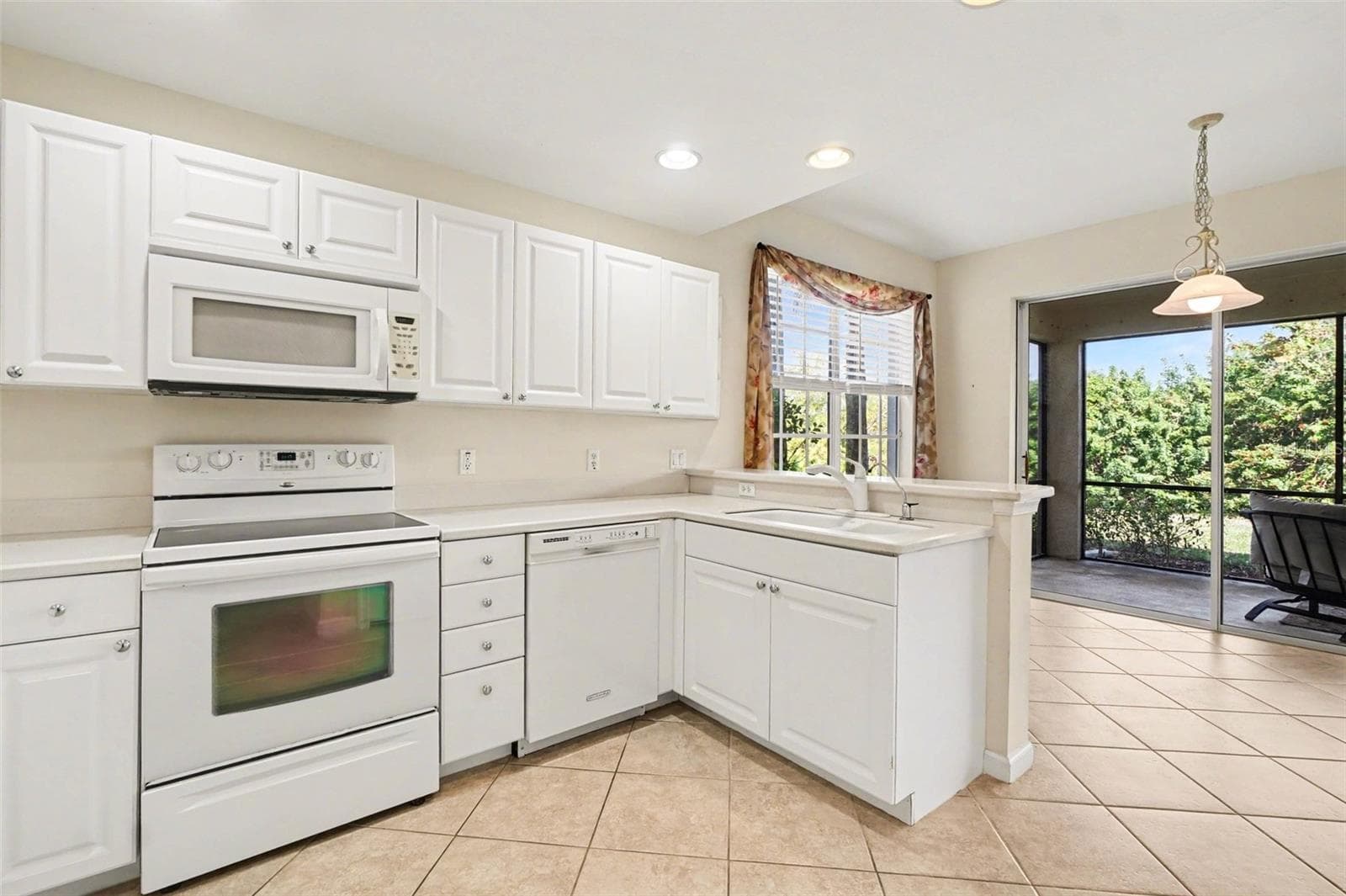 Bright and cheery kitchen with light flowing in from lanai and dining windows - 4683 CLUB DR #101, PORT CHARLOTTE