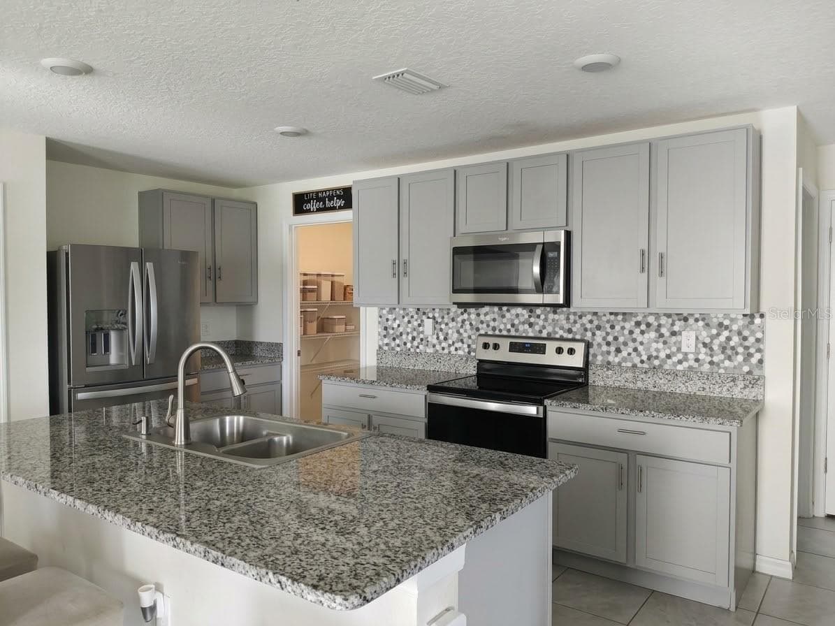 Open-concept kitchen "chef's triangle" - 5058 GRANITE DUST PL, PALMETTO