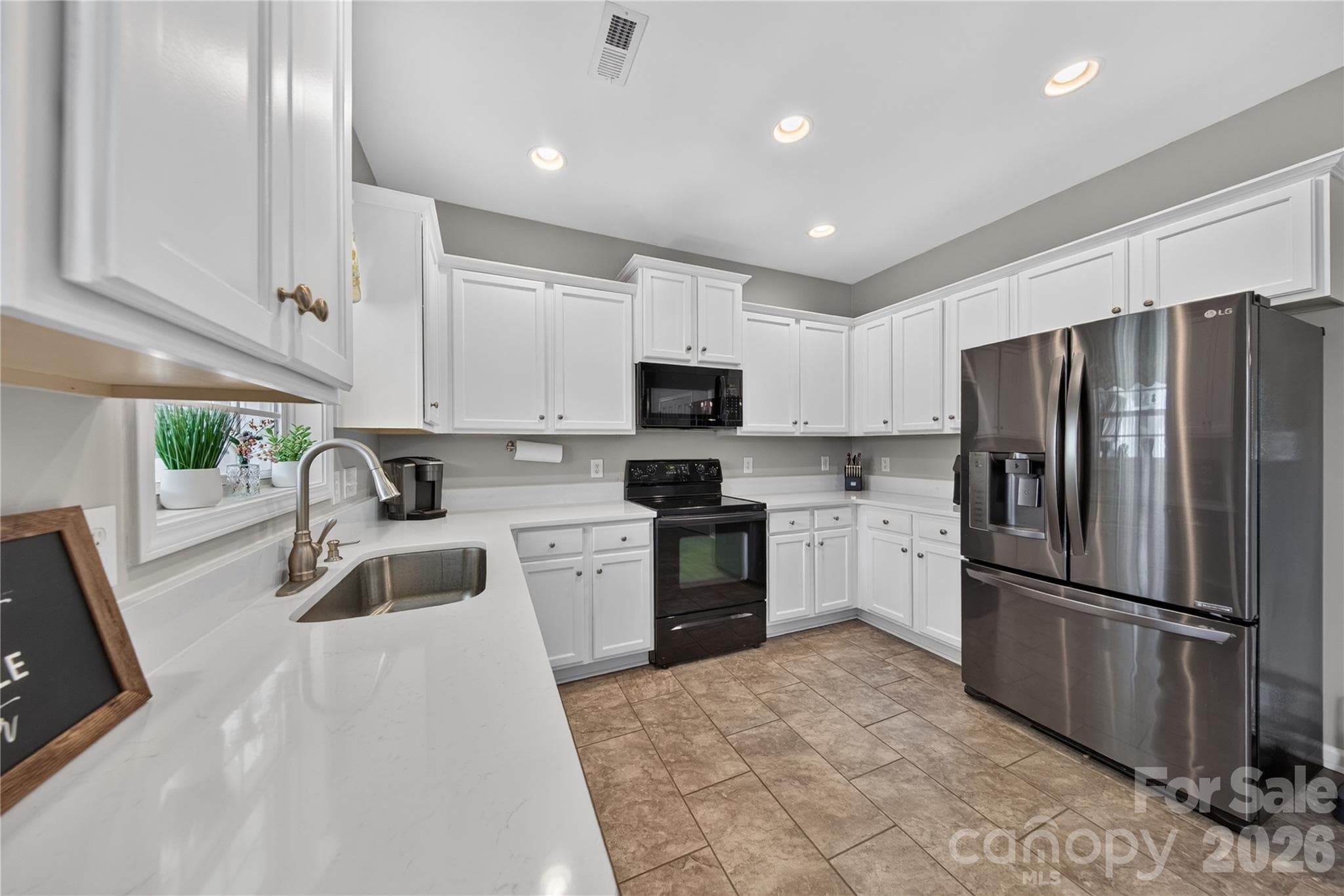 Angled view of kitchen with new quartz countertops and large single basin stainless sink - 5725 Lindley Crescent Drive, Indian Trail