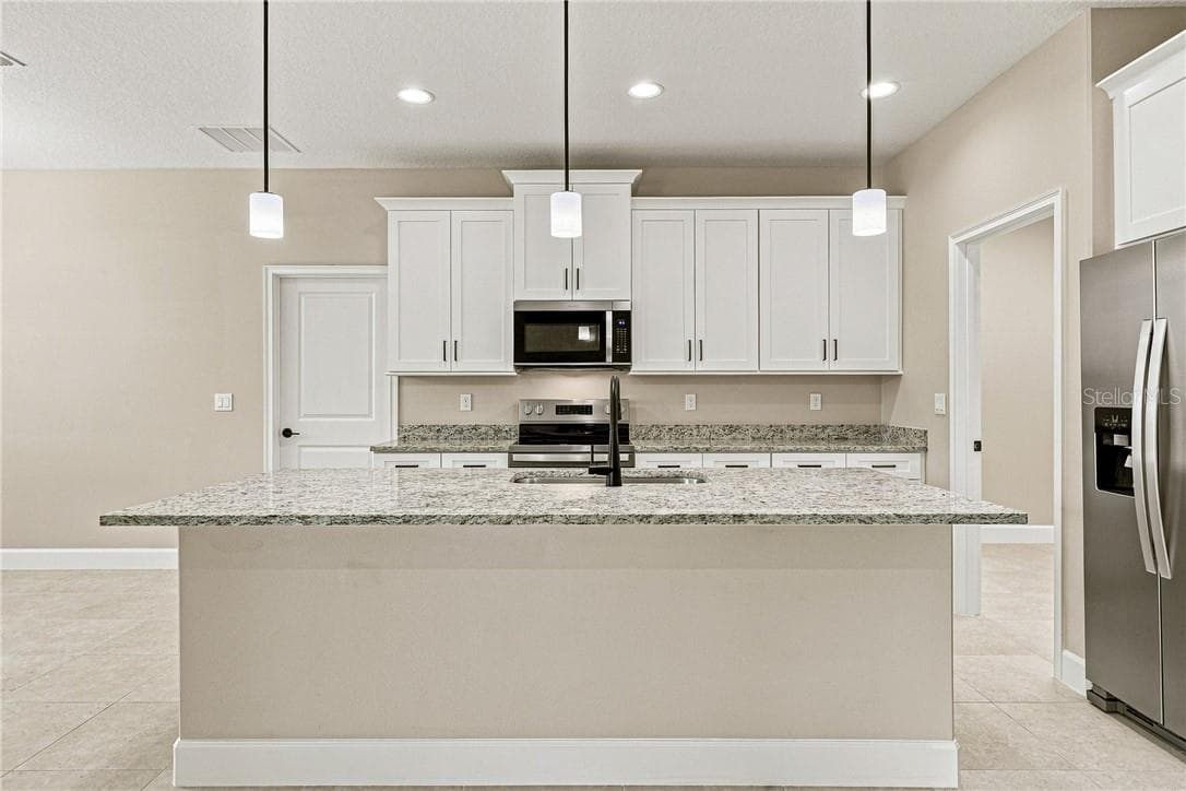 Upgraded kitchen including granite countertops, soft close cabinets, crown molding, and stainless steel appliances - 2171 Fallon BLVD NE, PALMBAY FL 32907, Palm Bay