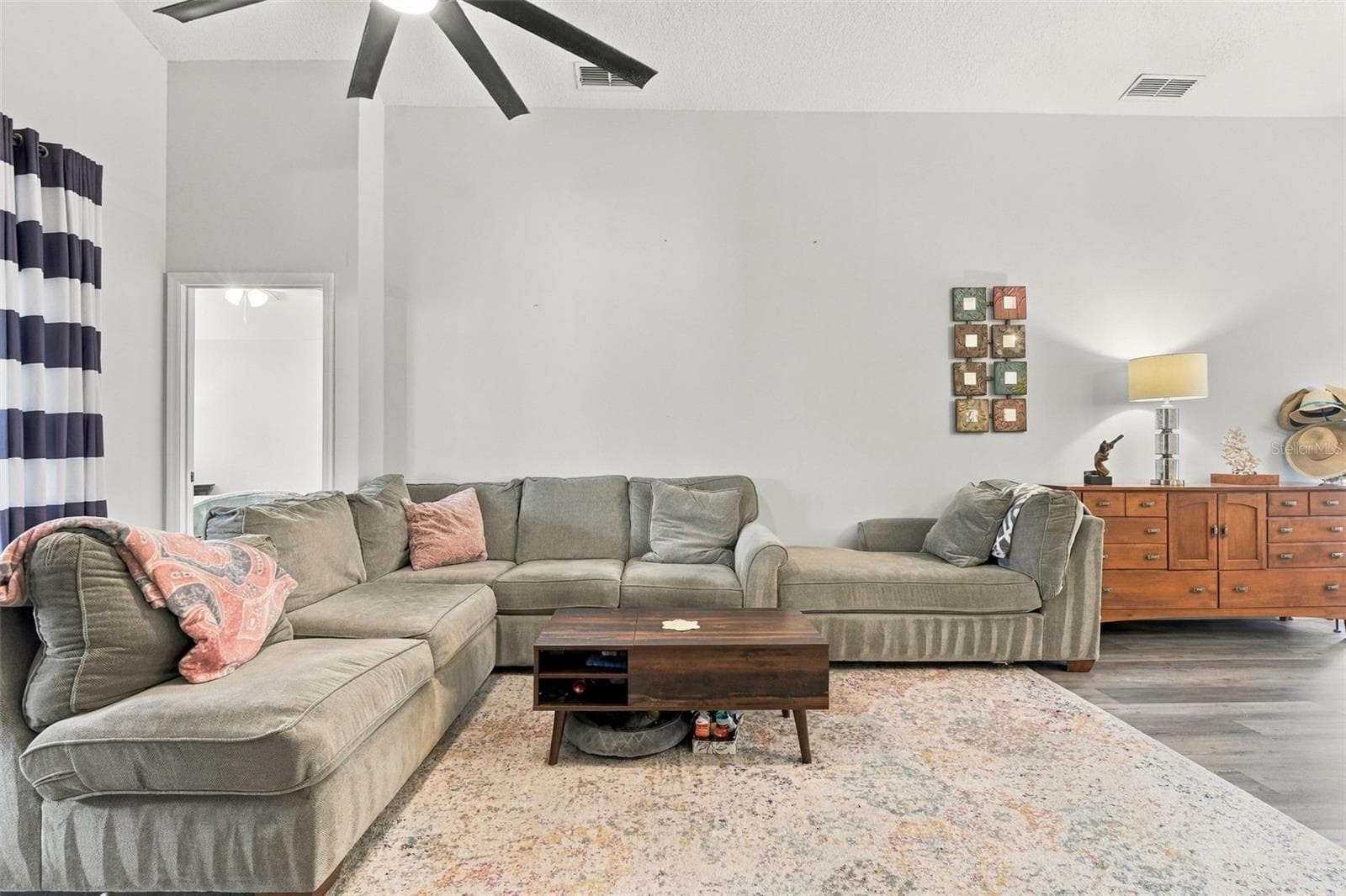 Main living area w/large sliding doors at left. Primary bedroom suite afar. - 430 DEANNA CIR, DELAND