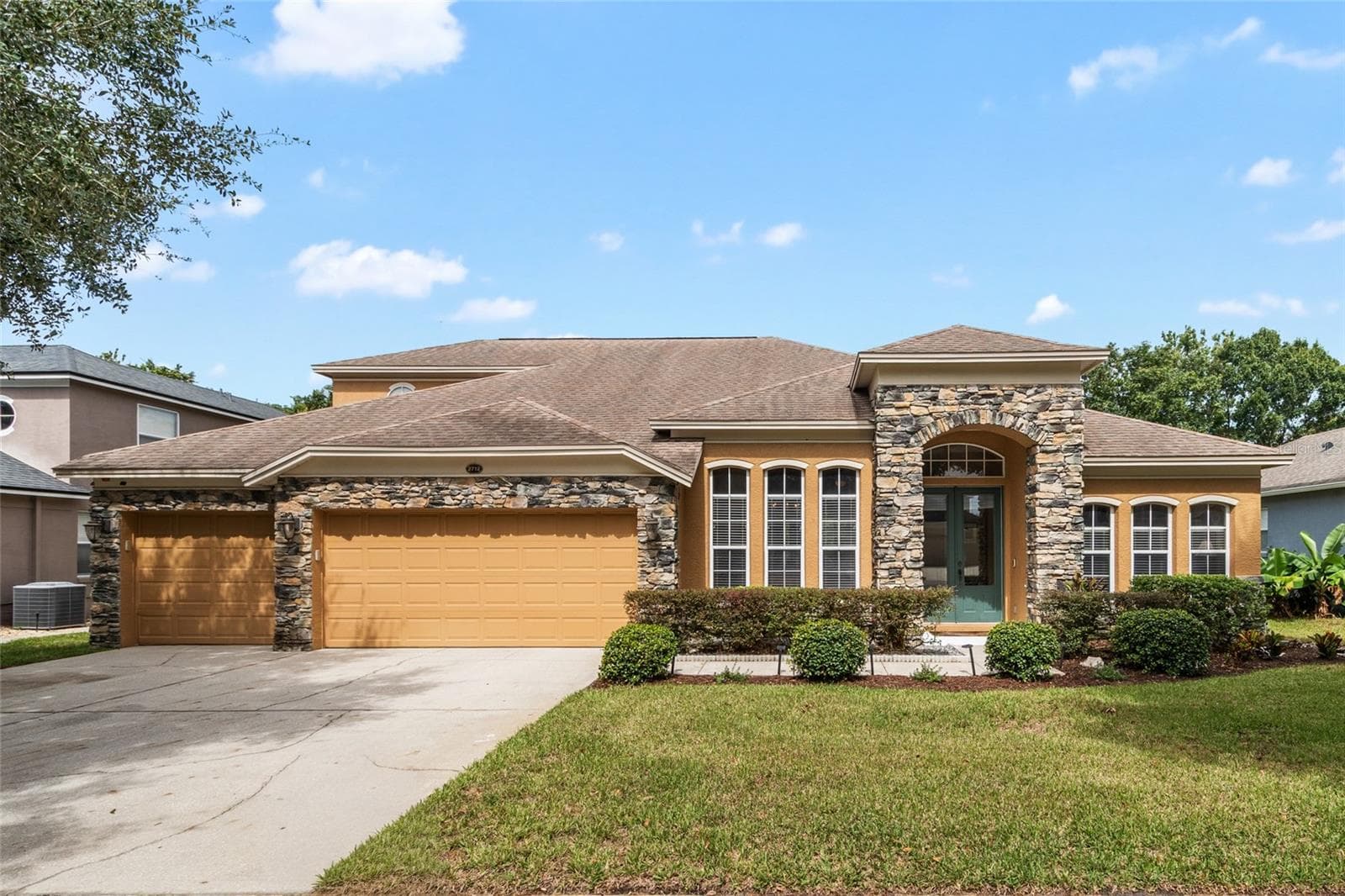 Front Elevation - 2 Story - Stone Facade with 3 Car Garage on a canopied tree lined street. - 2712 ALOMA OAKS DR, OVIEDO