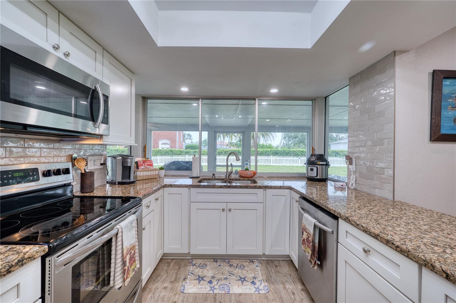 Kitchen with window sliders to the bar on the back lanai - 6316 5TH AVE NW, BRADENTON